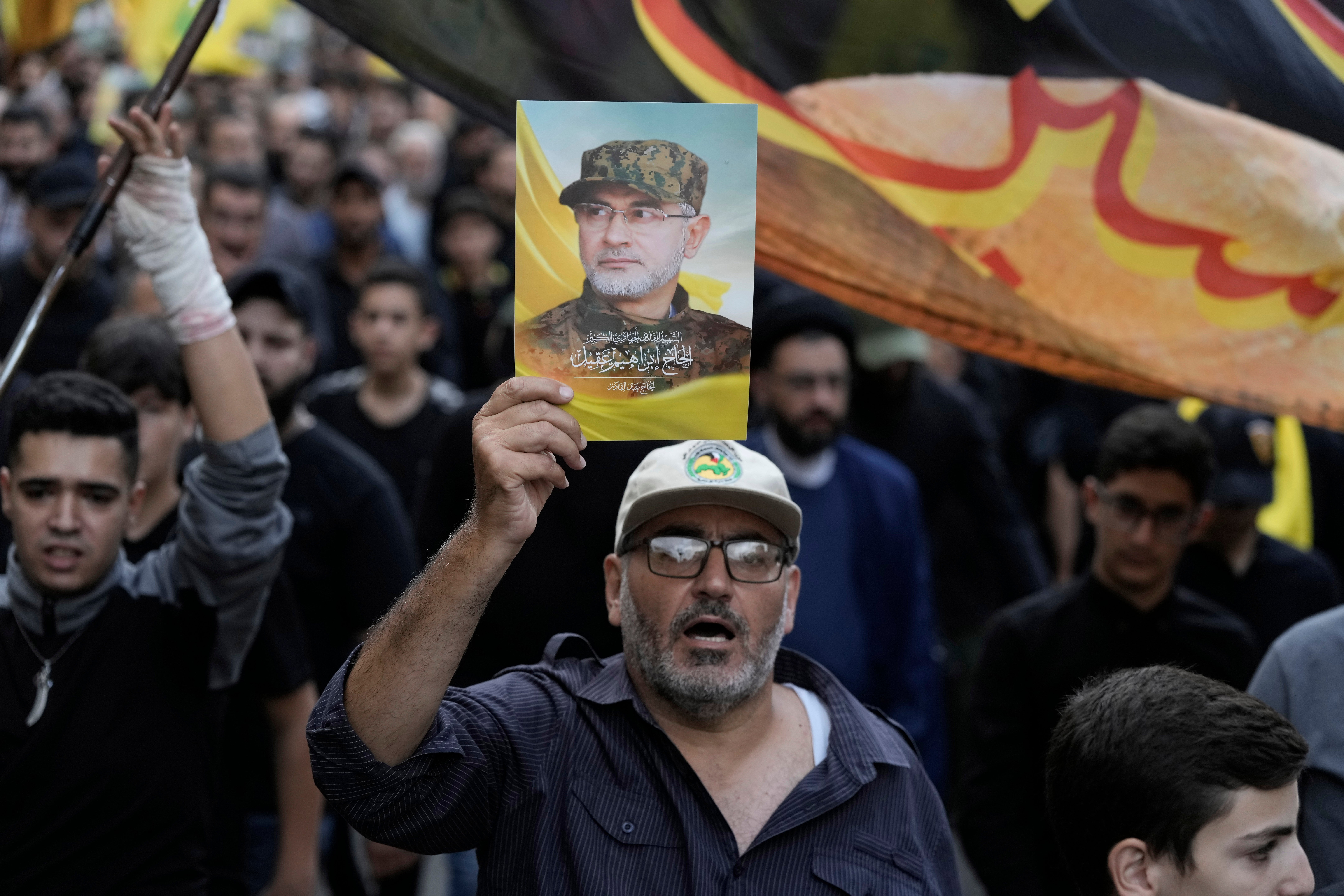 Hezbollah supporters carry pictures of Hezbollah commander Ibrahim Akil during his funeral procession in Beirut's southern suburb, Sunday, Sept. 22, 2024. (AP Photo/Bilal Hussein)