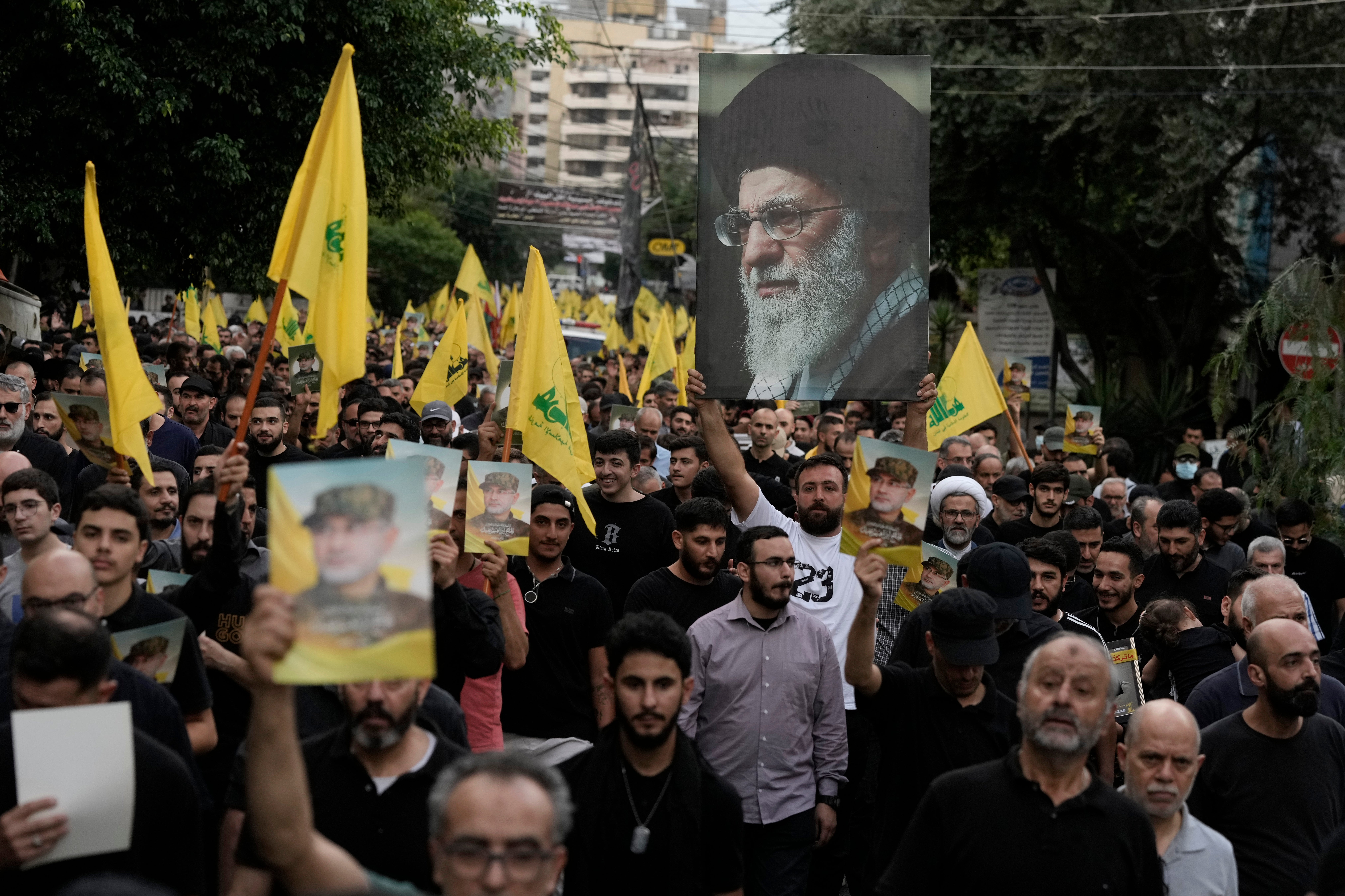 Hezbollah supporters carry pictures of Hezbollah commander Ibrahim Akil and Supreme Leader Ayatollah Ali Khamenei during Akil's funeral procession in Beirut's southern suburb last weekend