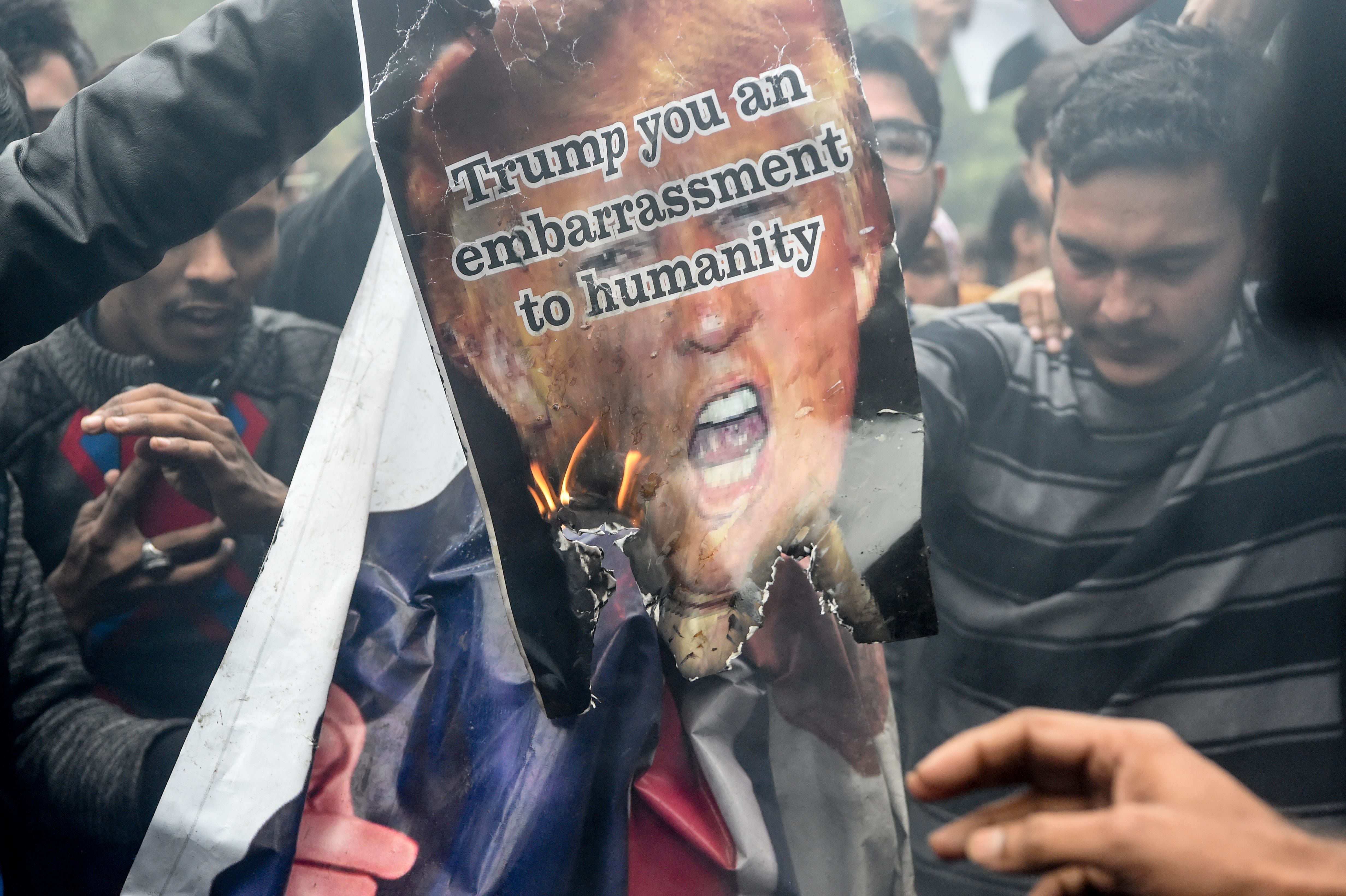 People burn a poster of Donald Trump to protest against the US authorities for the killing of Iranian commander Qassem Soleimani in Iraq