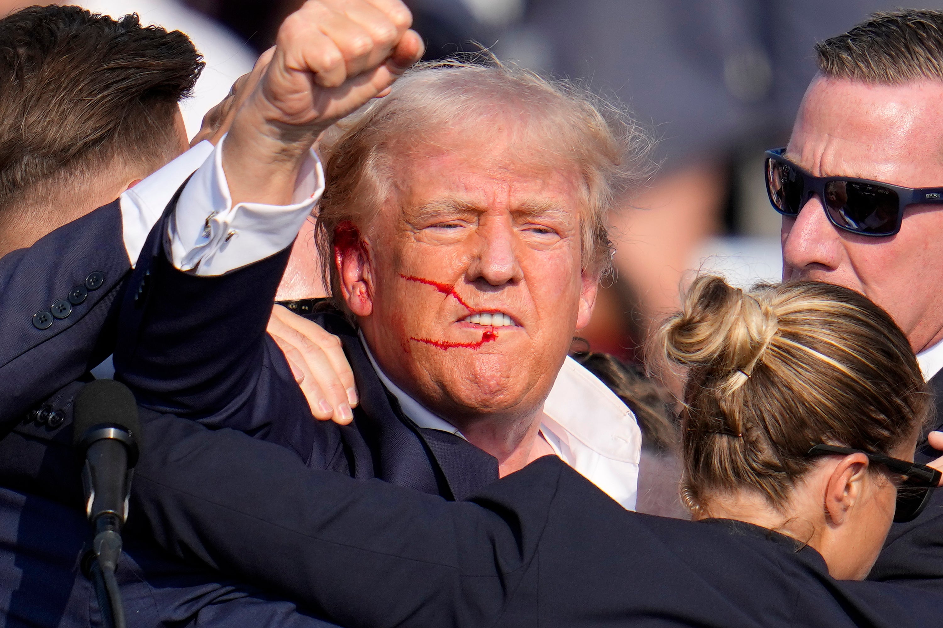 Trump pumps his fist into the air following the assassination attempt at his Butler rally in July