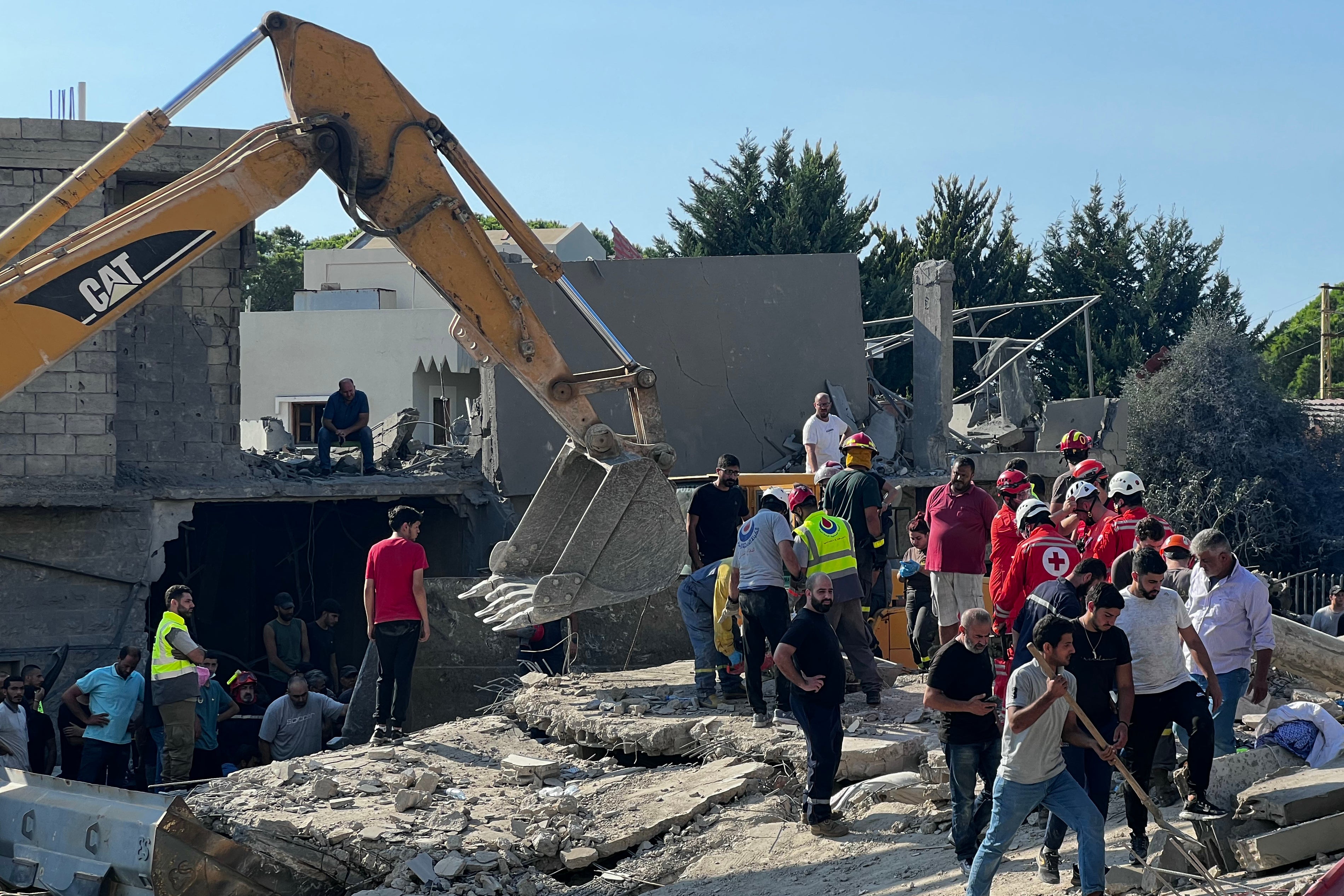 People gather at the site of an Israeli strike on the Mount Lebanon village of Maaysra, east of the Christian coastal town of Byblos, Lebanon