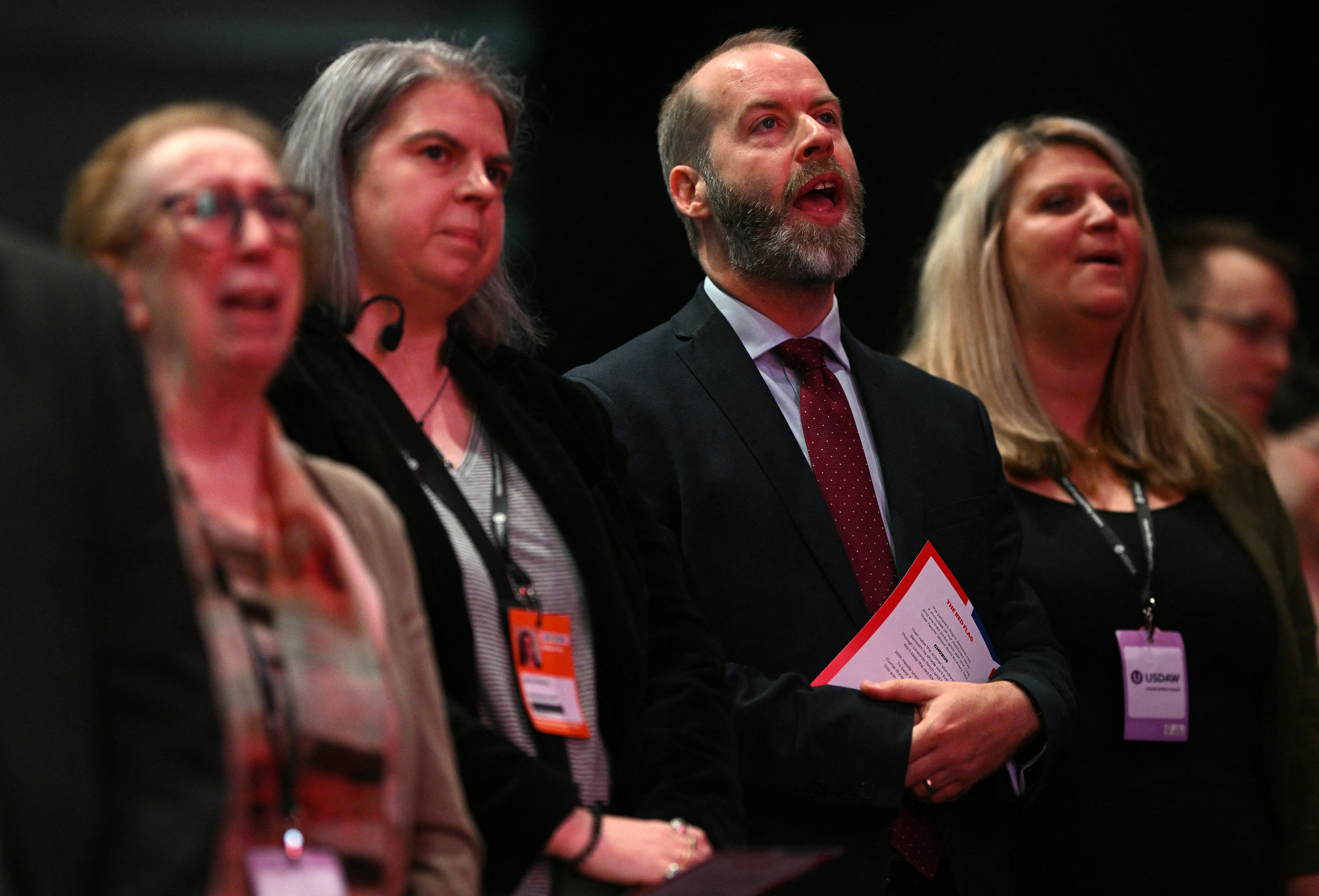 Business, Energy and Industrial Strategy Secretary Jonathan Reynolds (2R) sings 'The Red Flag' song