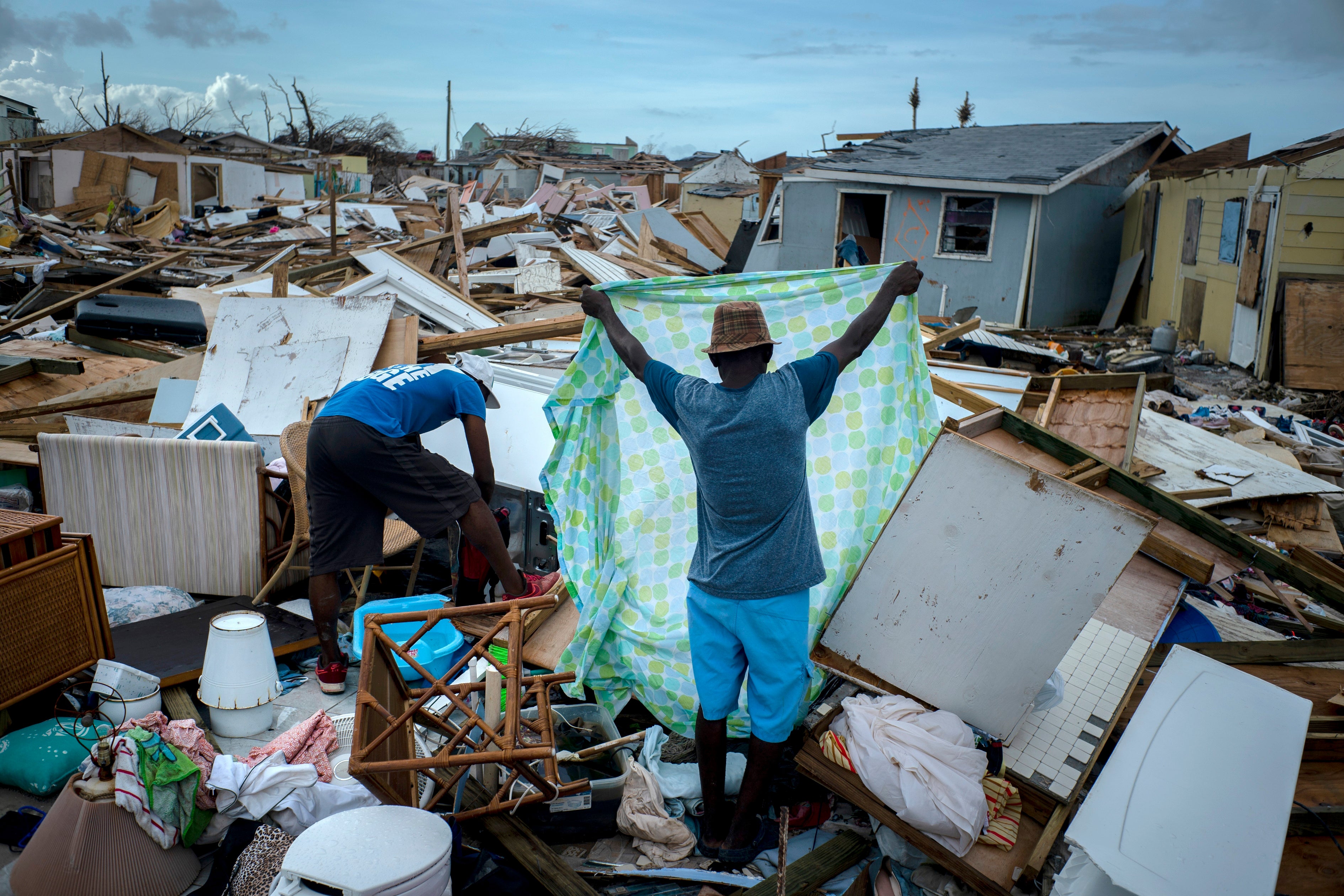 Immigrants from Haiti recover their belongings from the rubble in their destroyed homes, in the aftermath of Hurricane Dorian in Abaco, Bahamas
