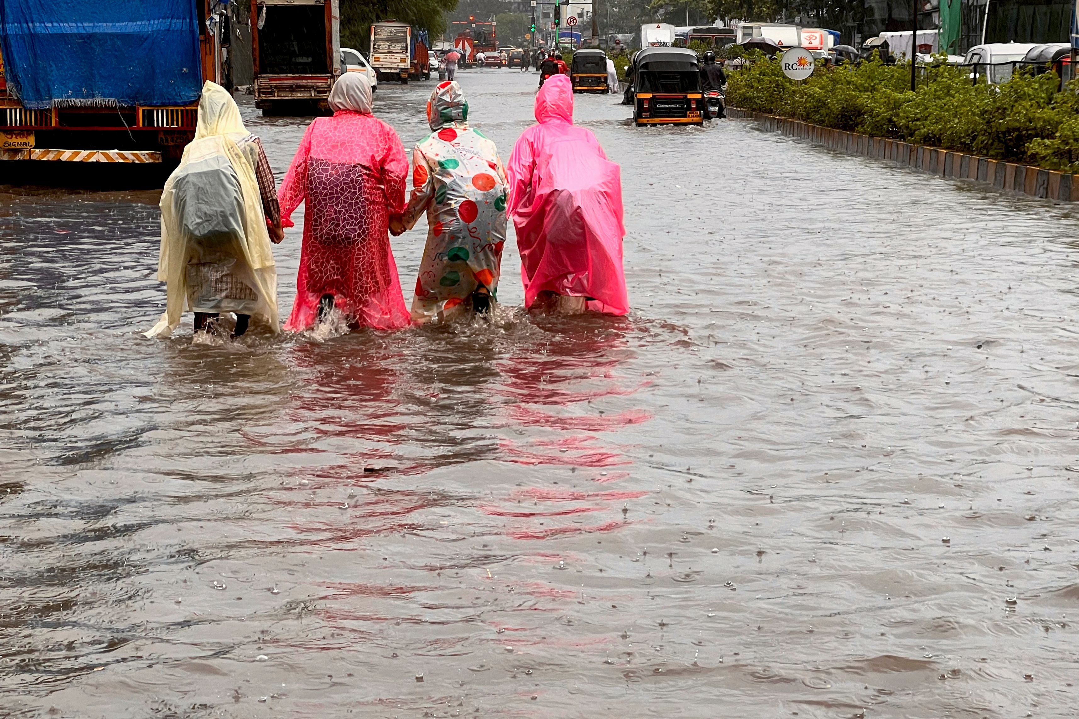 File. Schoolchildren wade through a waterlogged road after heavy monsoon rainfall in Mumbai, India, on 21 July 2023