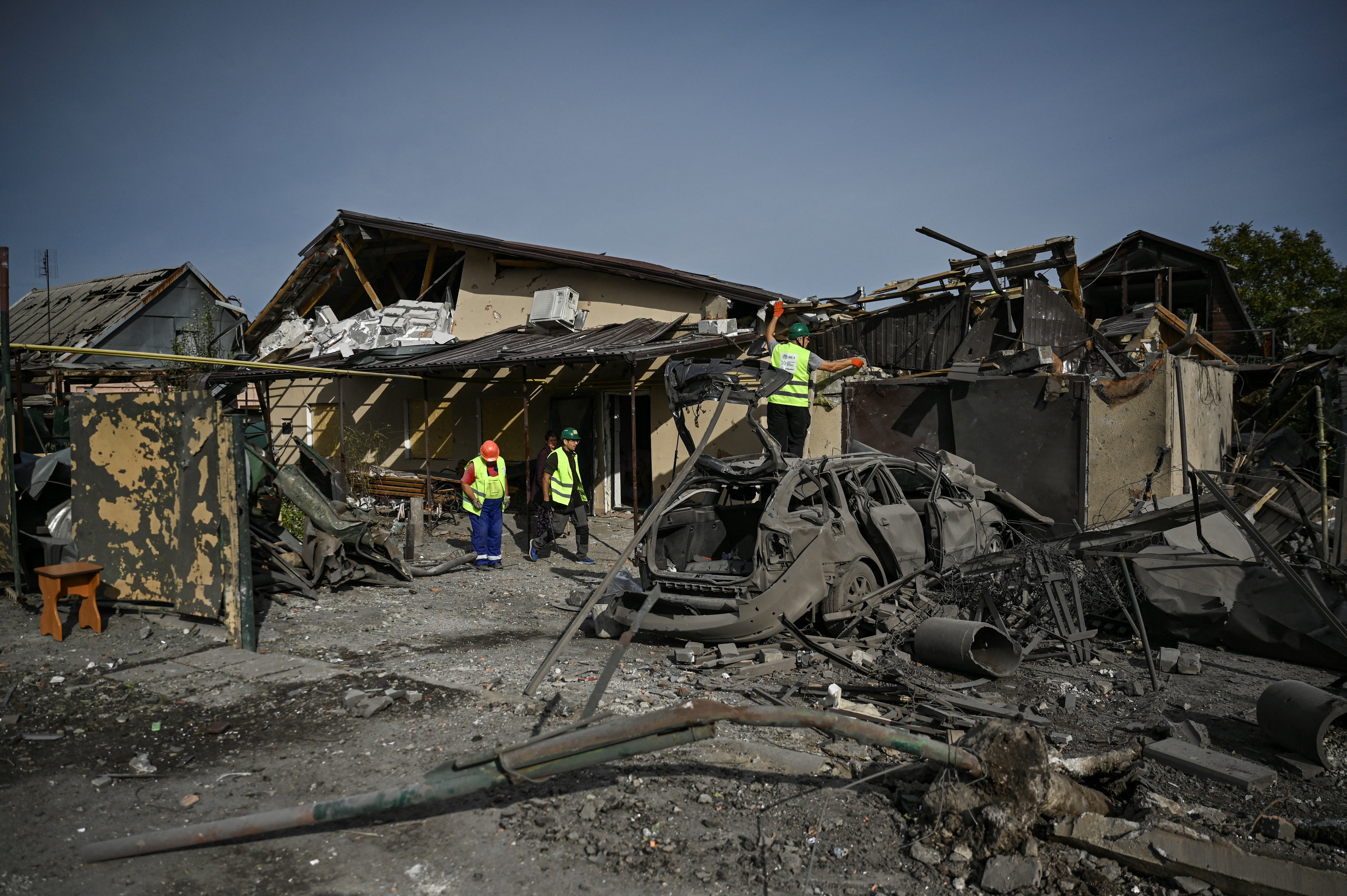 Municipal workers remove debris at a site of a residential area heavily damaged by a Russian air strike in Zaporizhzhia, south east Ukraine