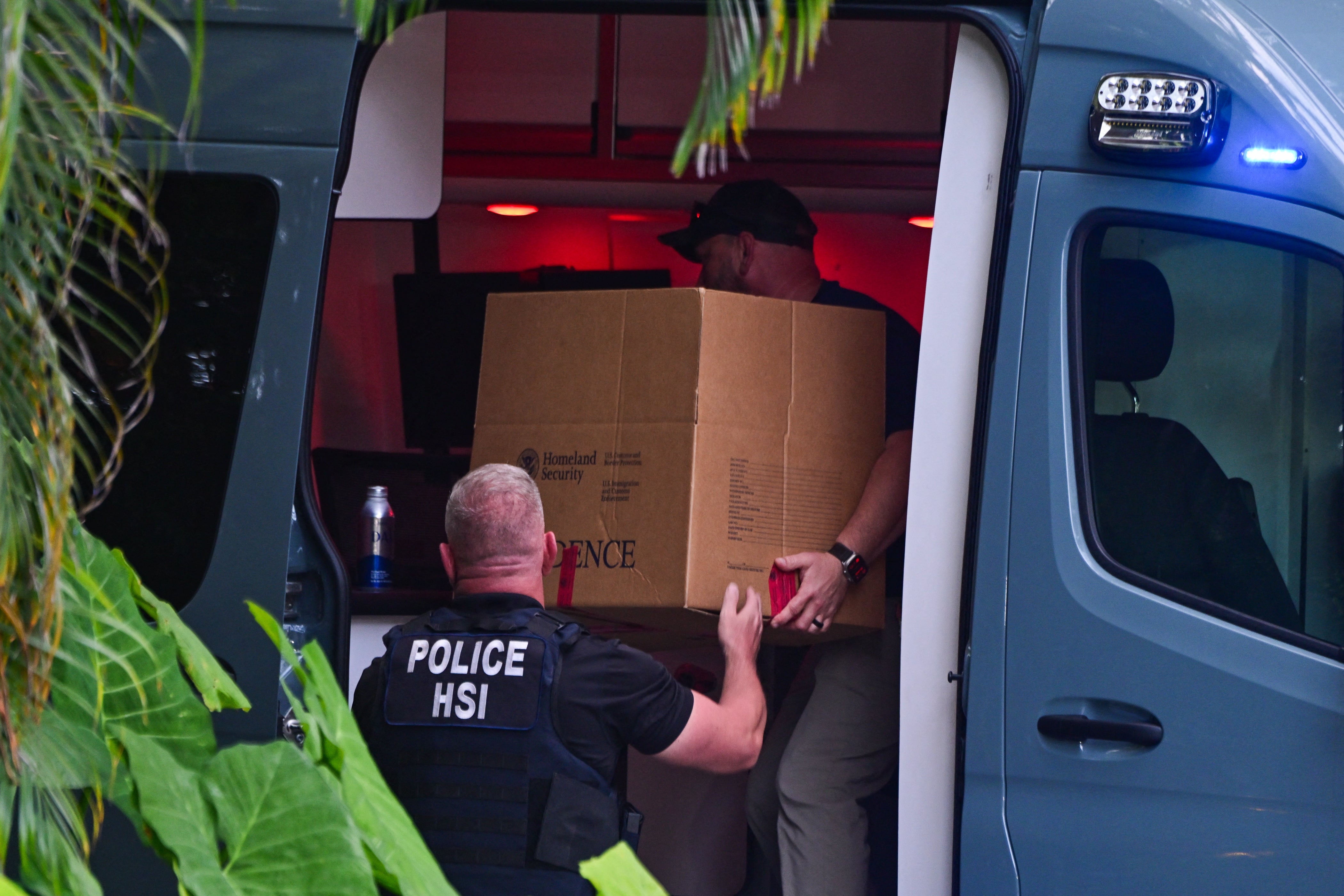 Homeland Security Investigation agents load a box into a car at the entrance of Diddy’s Miami home in March