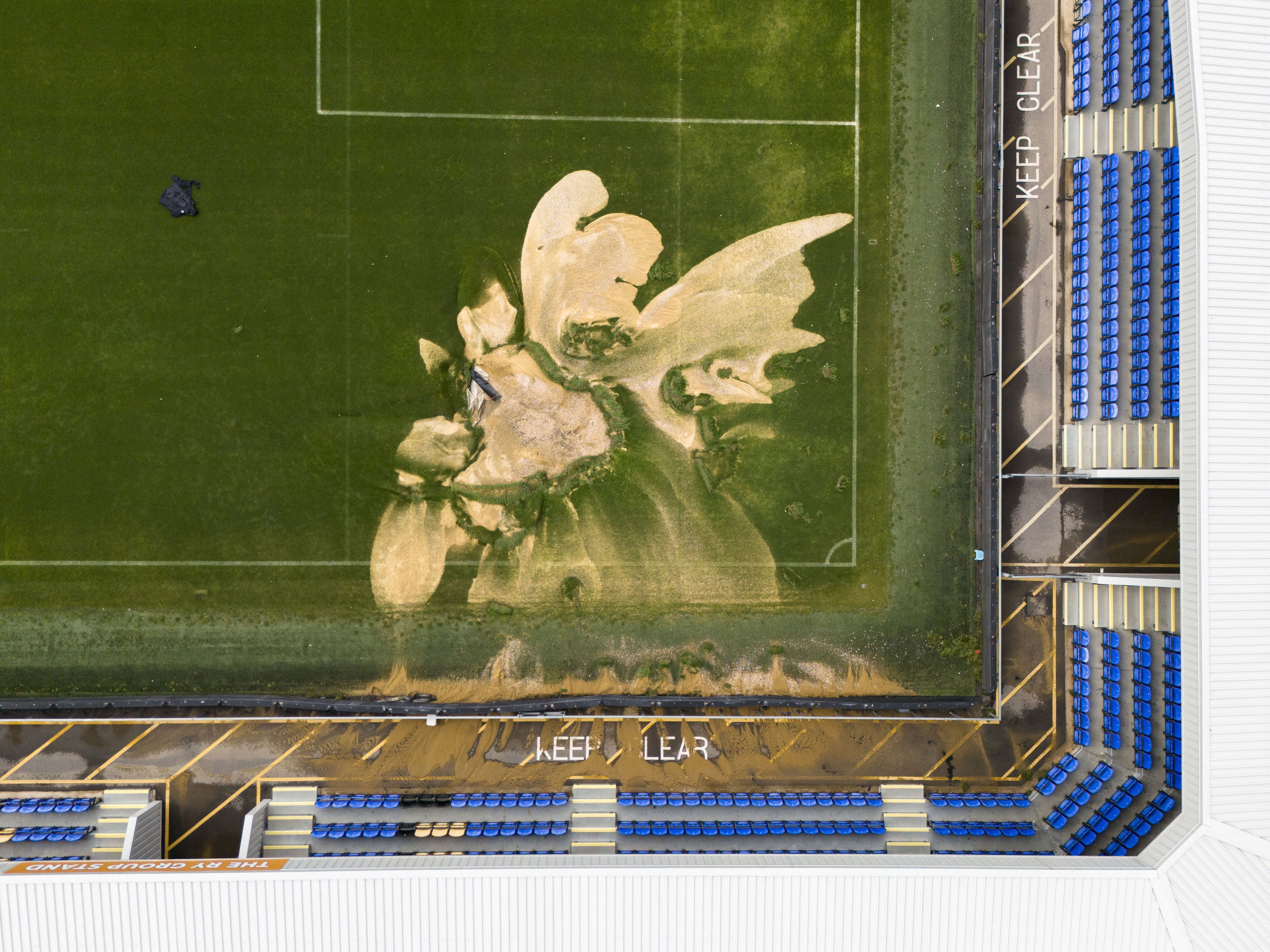 A sinkhole on the pitch and flooded walkways at the Cherry Red Records Stadium, home of AFC Wimbledon