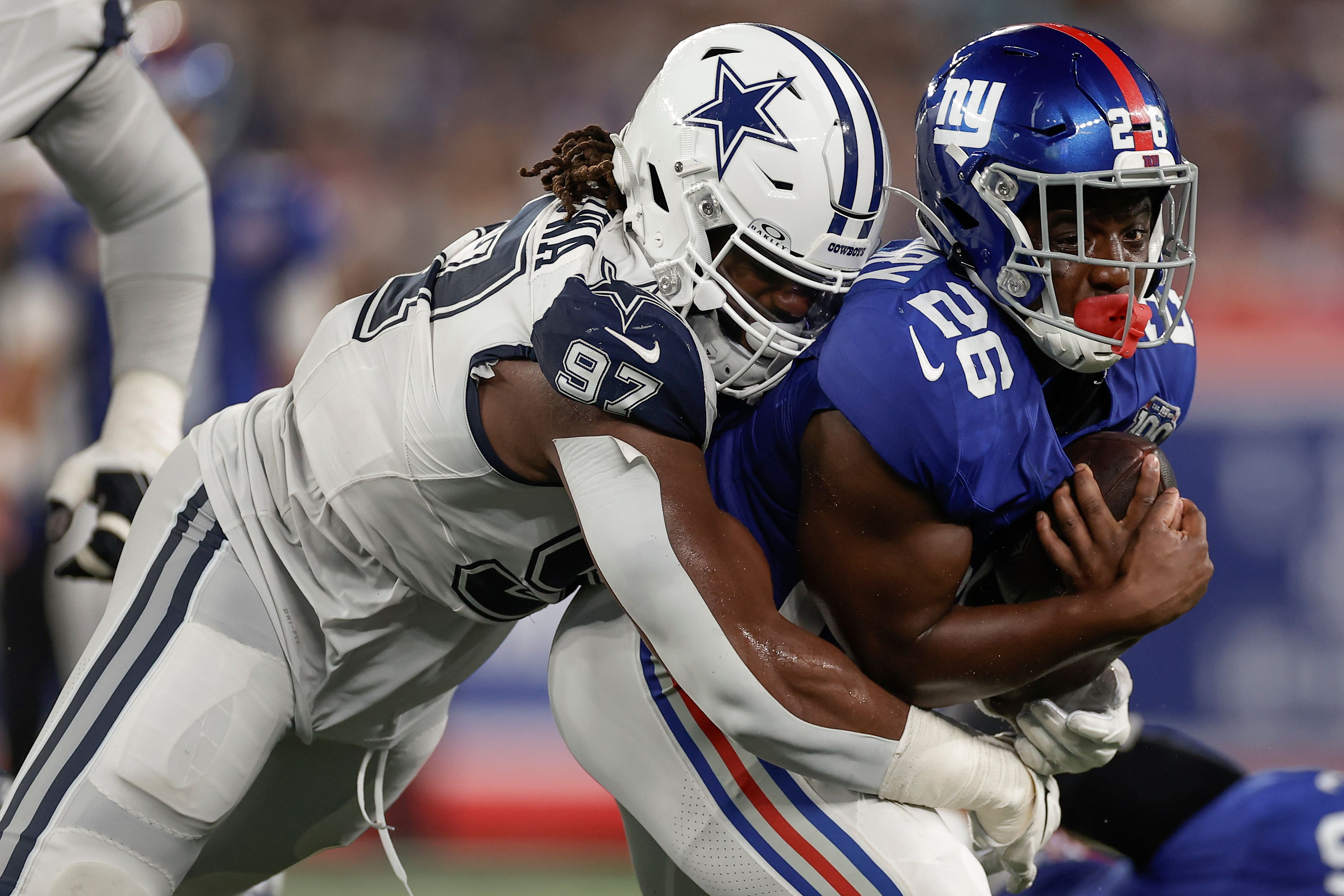 Dallas Cowboys defensive tackle Osa Odighizuwa (97) tackles New York Giants running back Devin Singletary (26) during the second quarter of an NFL football game, Thursday, Sept. 26, 2024, in East Rutherford, N.J. (AP Photo/Adam Hunger)