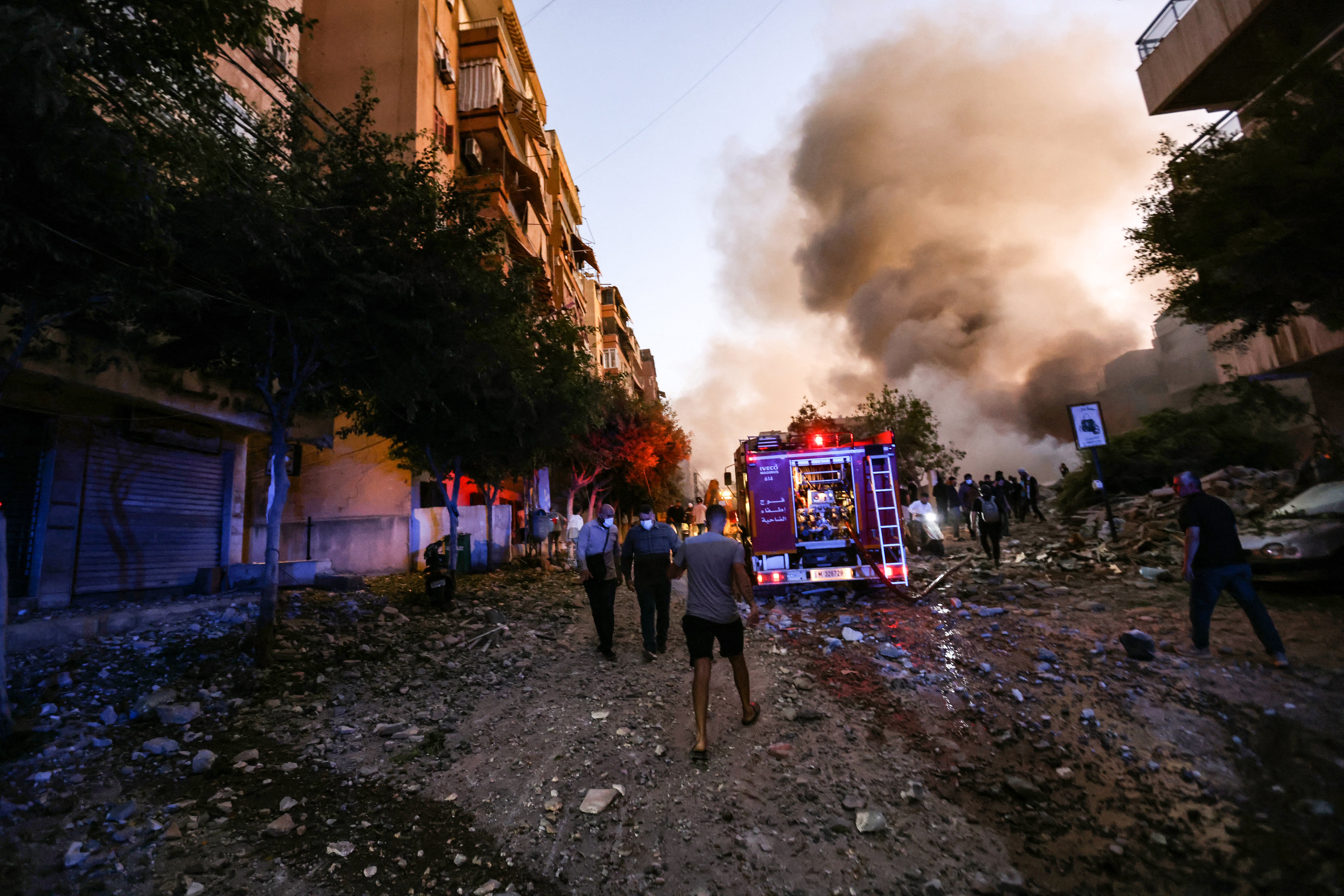 People and a fire truck rush to the scene of an Israeli air strike in the Haret Hreik neighbourhood in Beirut