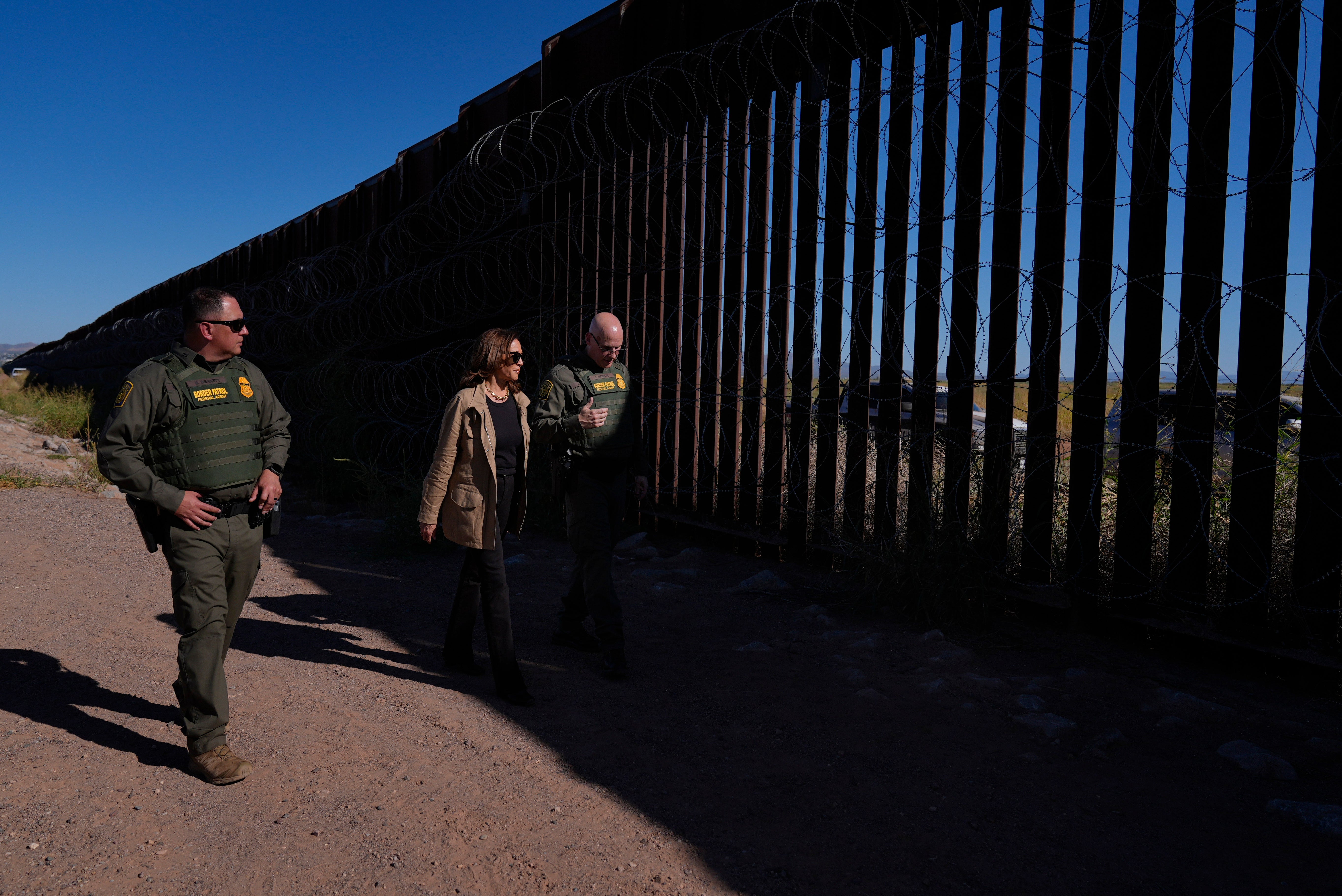 Democratic presidential nominee Vice President Kamala Harris talks with John Modlin, the chief patrol agent for the Tucson Sector of the U.S. Border Patrol, right, and Blaine Bennett, the U.S. Border Patrol Douglas Station border patrol agent in charge, as she visits the U.S. border with Mexico in Douglas, Arizona, on Friday