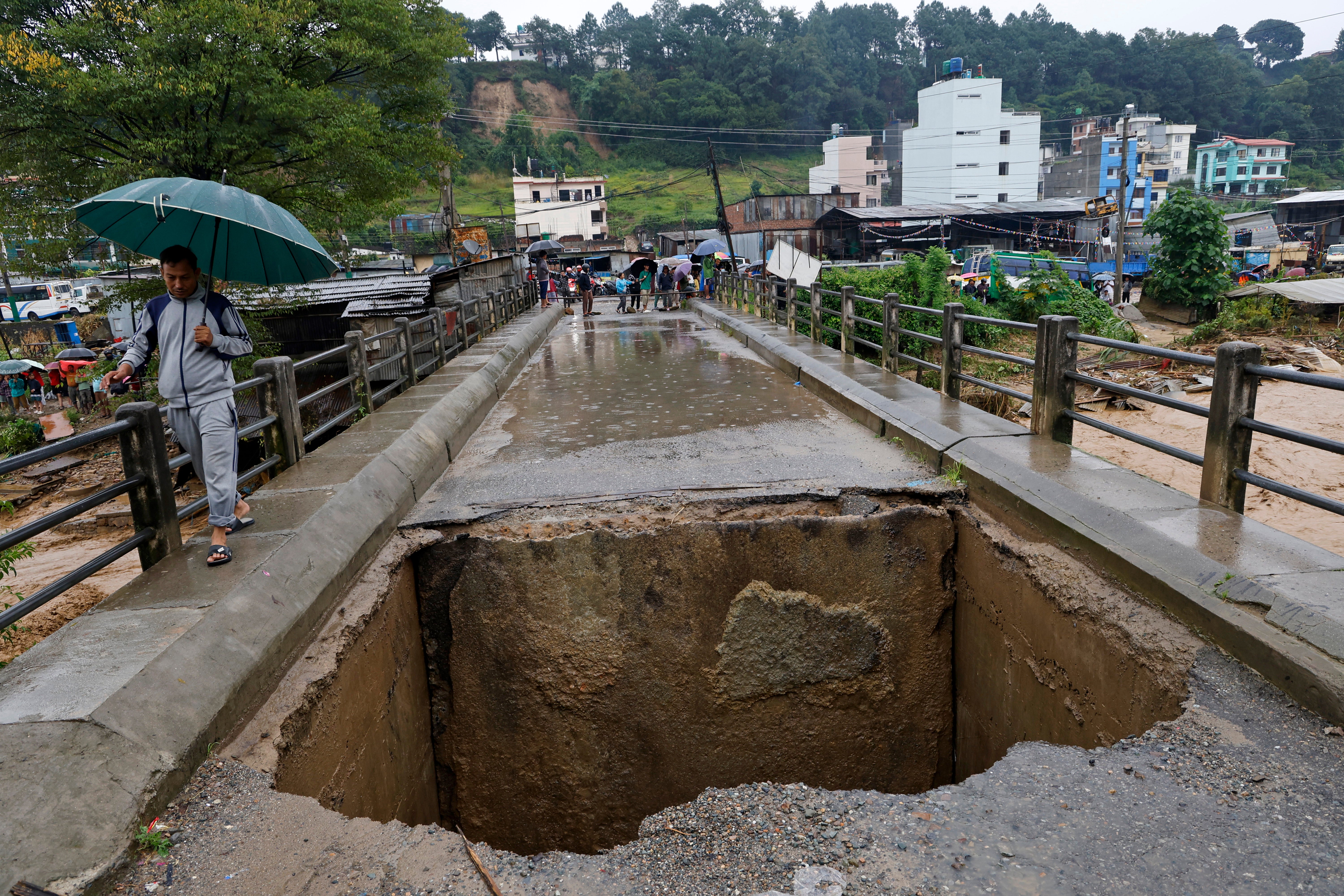 A bridge over Bagmati River lies damaged due to floods caused by heavy rains in Kathmandu