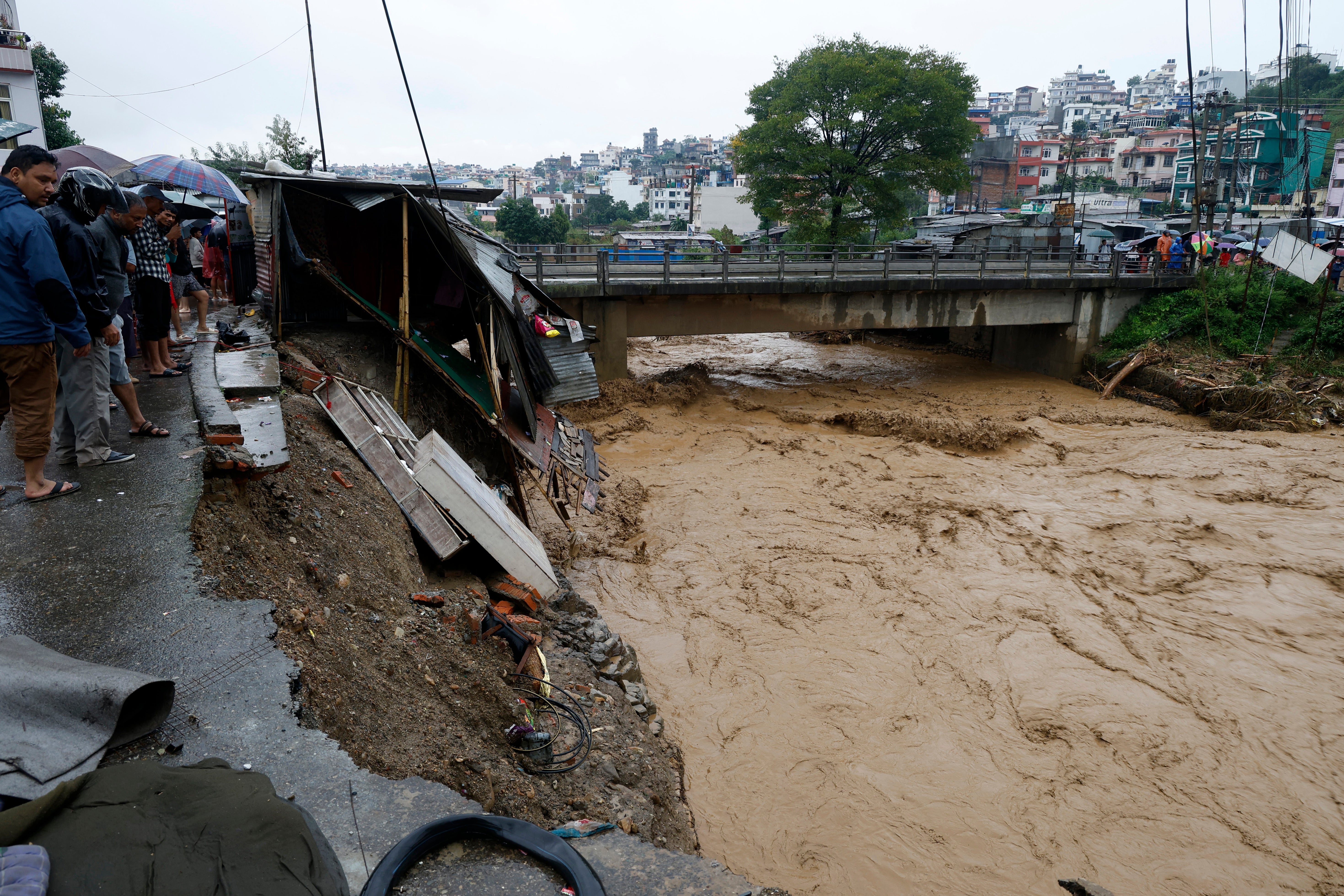 People gather at the edge of the Bagmati River in spate after heavy rains in Kathmandu, Nepal, Saturday, 28 Sept 2024