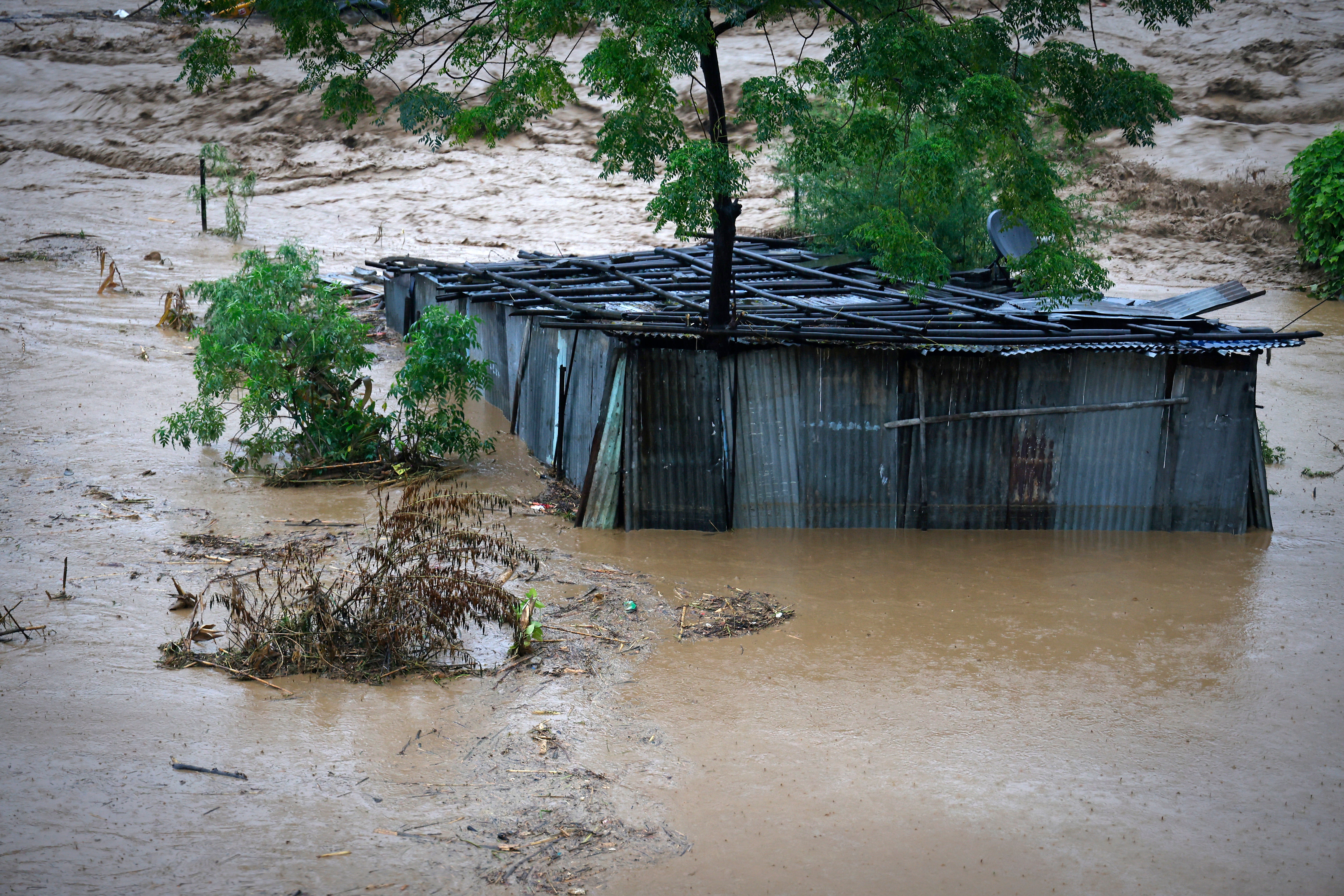 A tin shed lies partially submerged at the edge of the Bagmati River in spate after heavy rains in Kathmandu, Nepal, Saturday, 28 Sept 2024