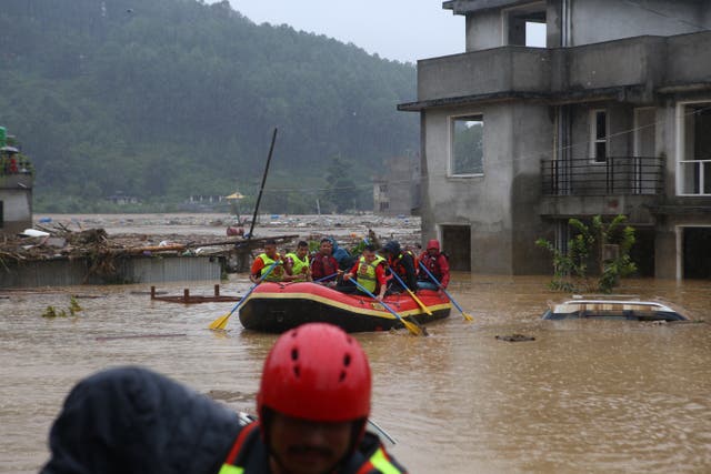 <p>Security force members use an inflatable raft to rescue residents from a flooded area near the bank of the overflowing Bagmati River</p>