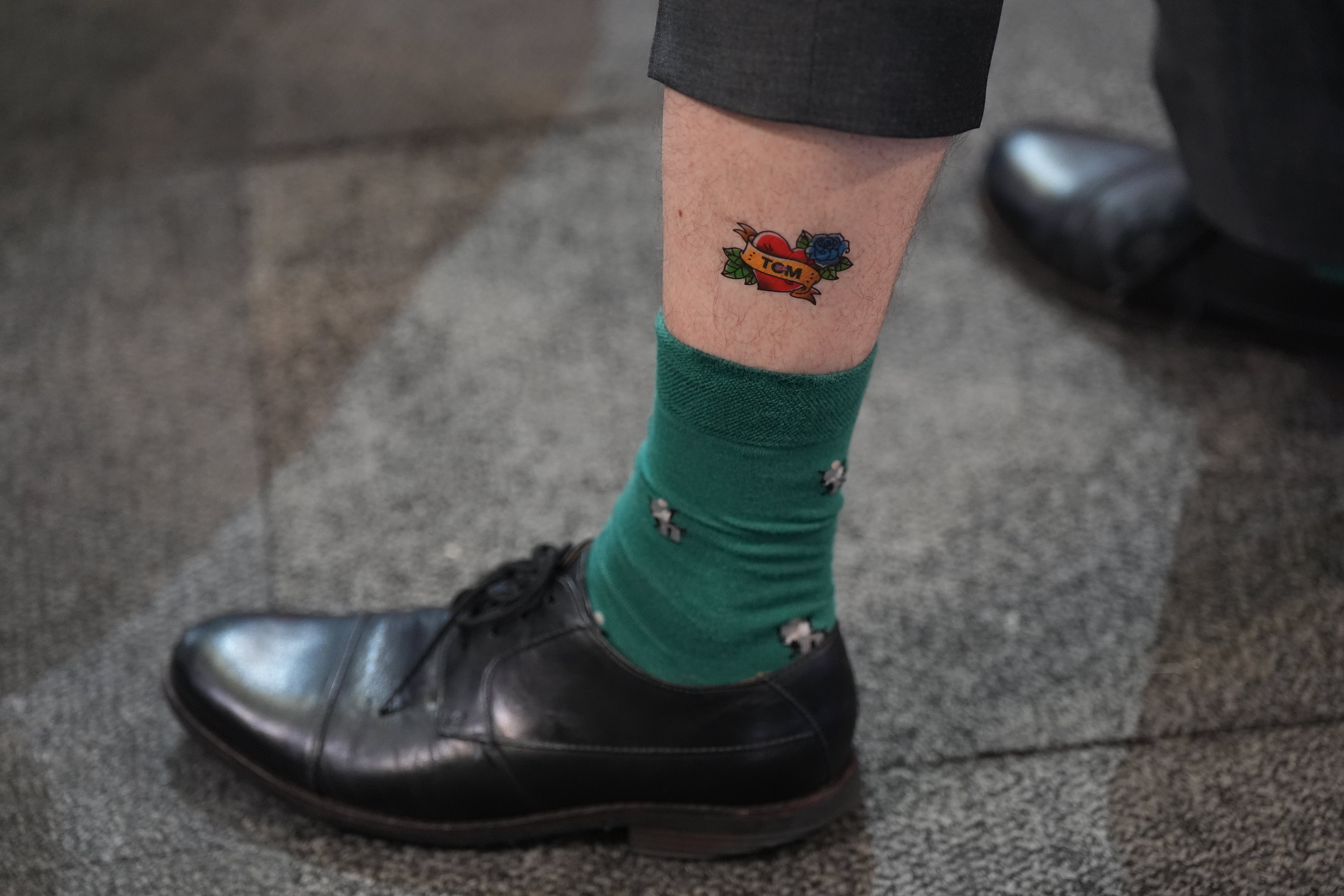 A man shows off his temporary Tom Tugendhat tattoo