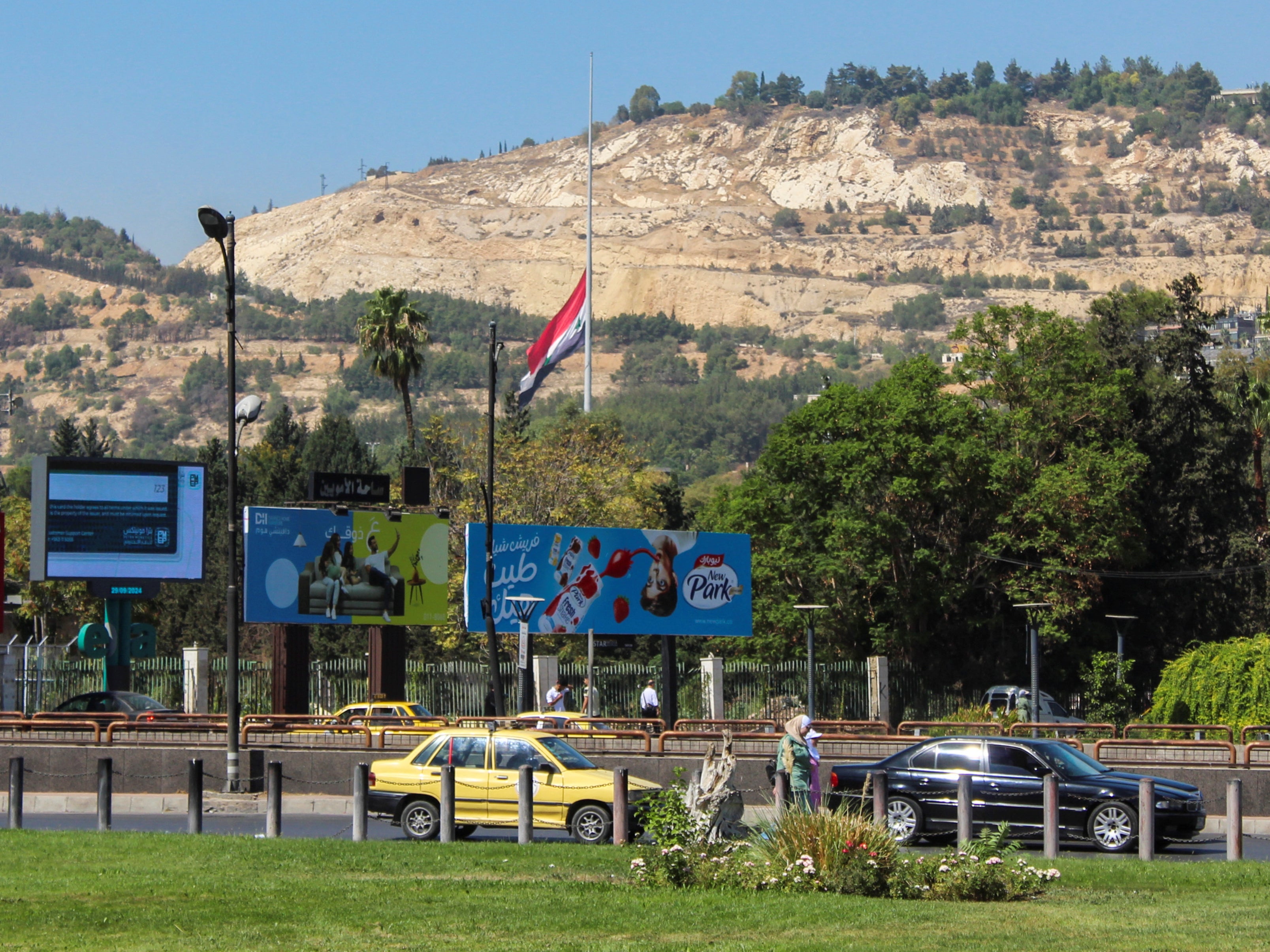 A Syrian flag flies at half mast during national mourning