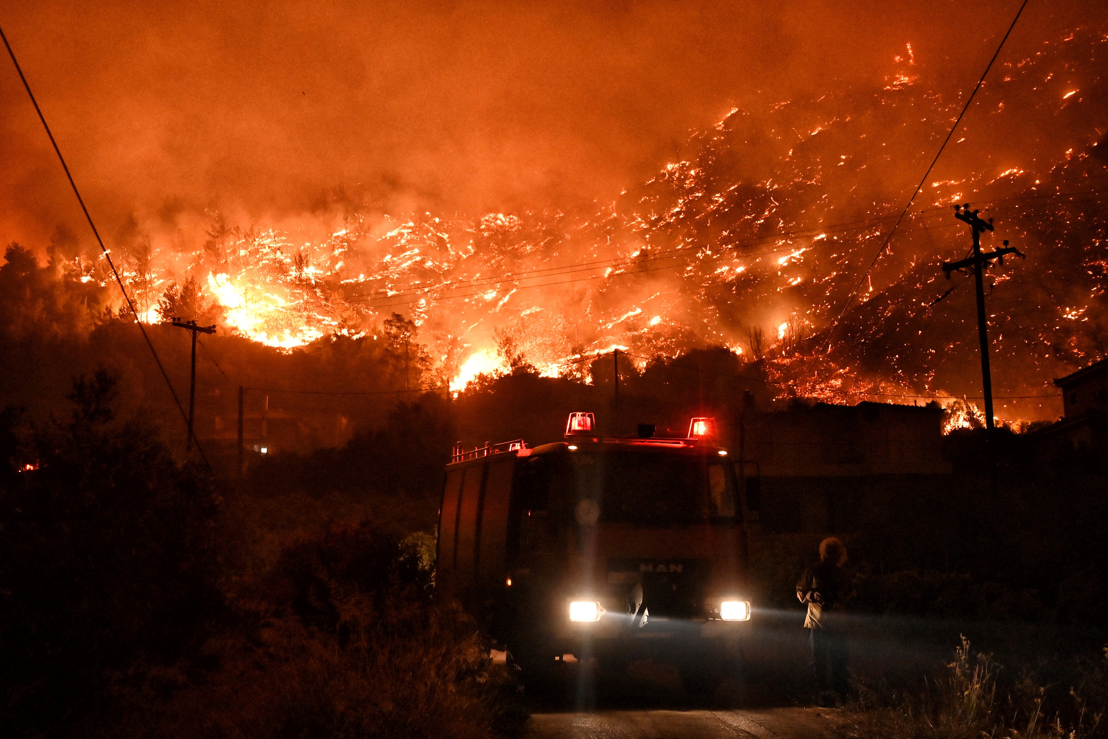 A wildfire approaches the village of Ano Loutro in Greece