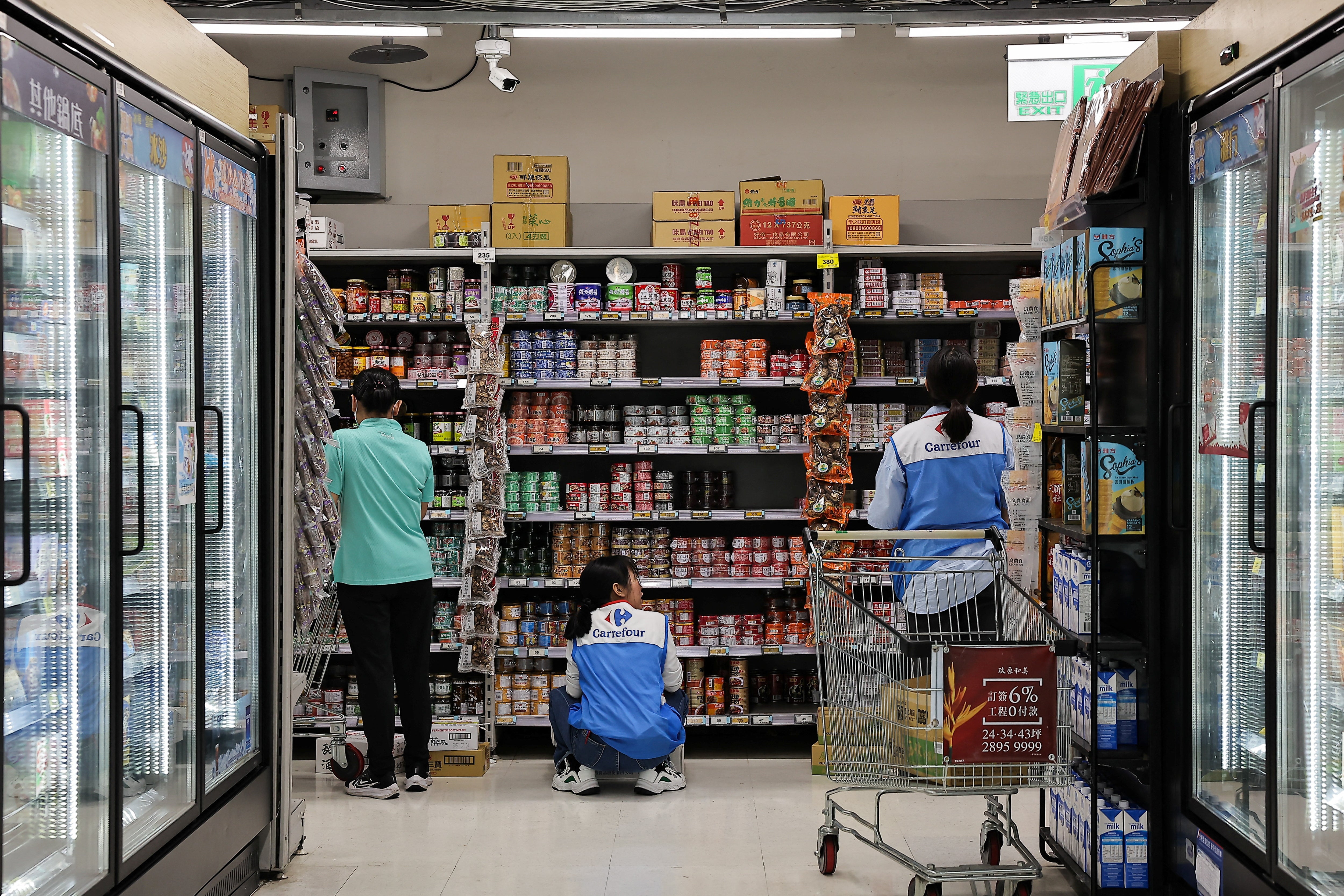 Staff stock canned food at a supermarket ahead of Typhoon Krathon which is expected to intensify and make an unusual landfall