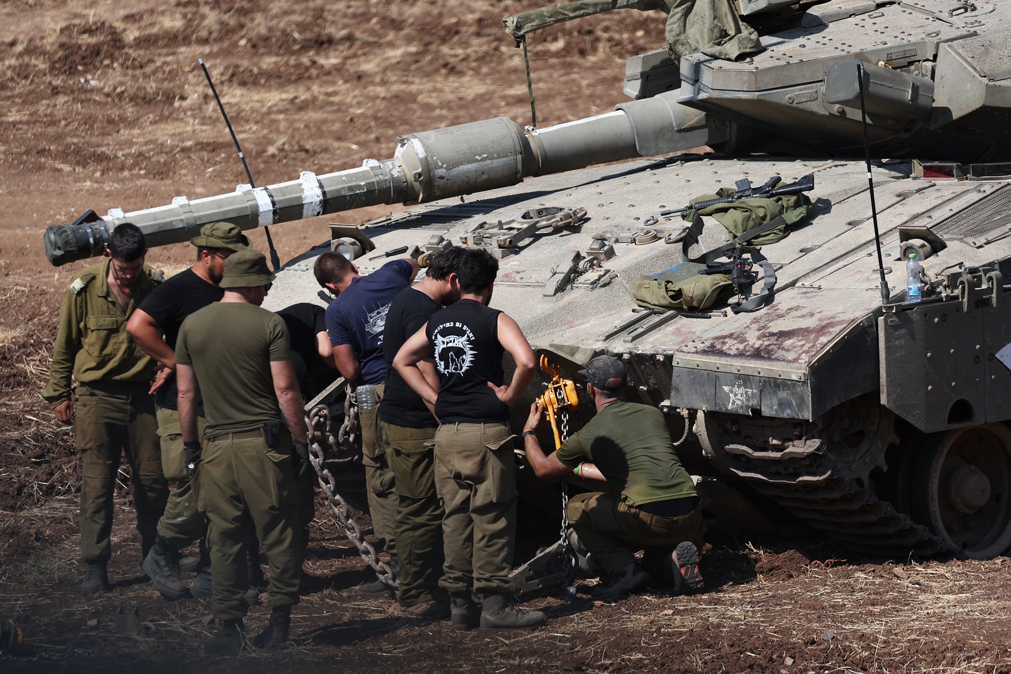 Israeli soldiers check a Merkava tank near the border with Lebanon