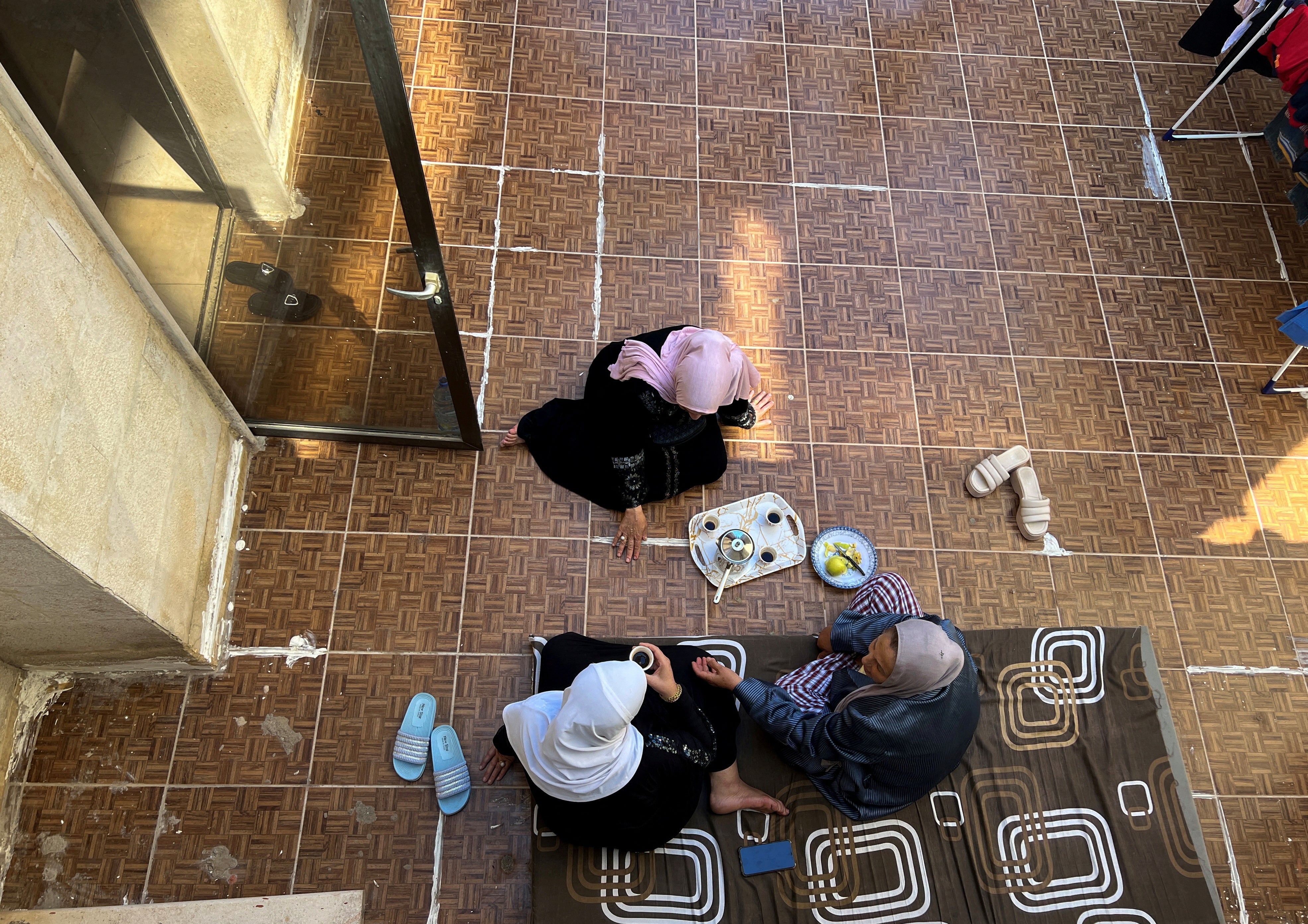 Displaced women from southern Lebanon have coffee on the terrace of an apartment in a building hosting displaced people