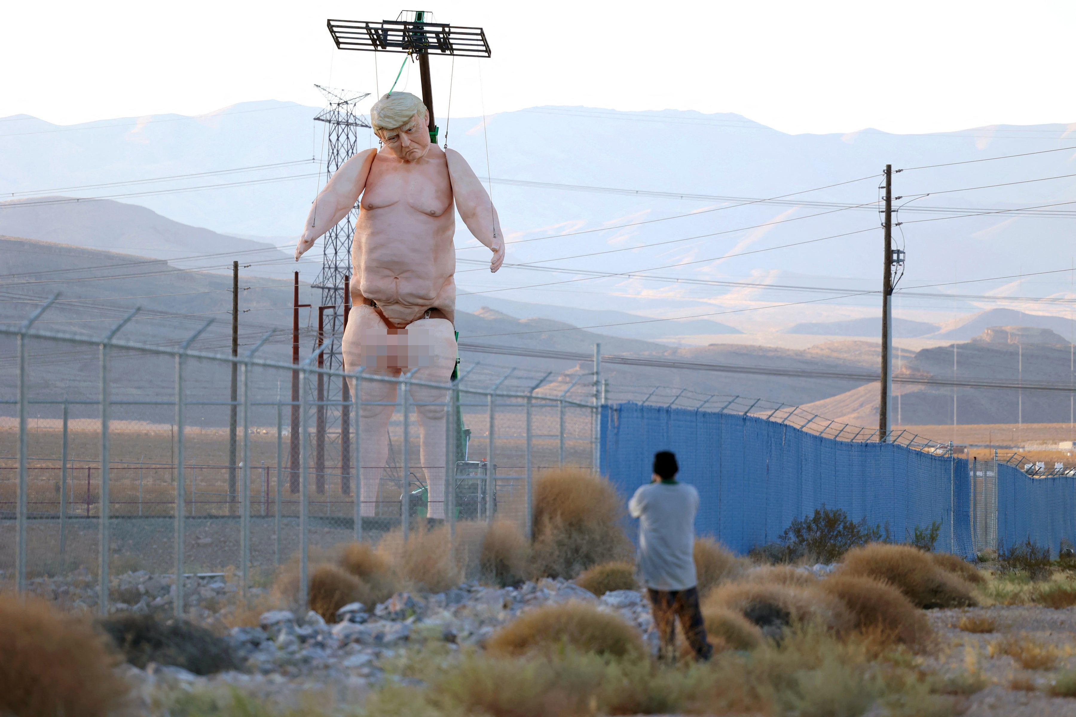 A 43-foot-tall naked statue resembling Donald Trump is displayed in a fenced-in lot near Interstate 15 north of Las Vegas, Nevada, September 28, 2024.