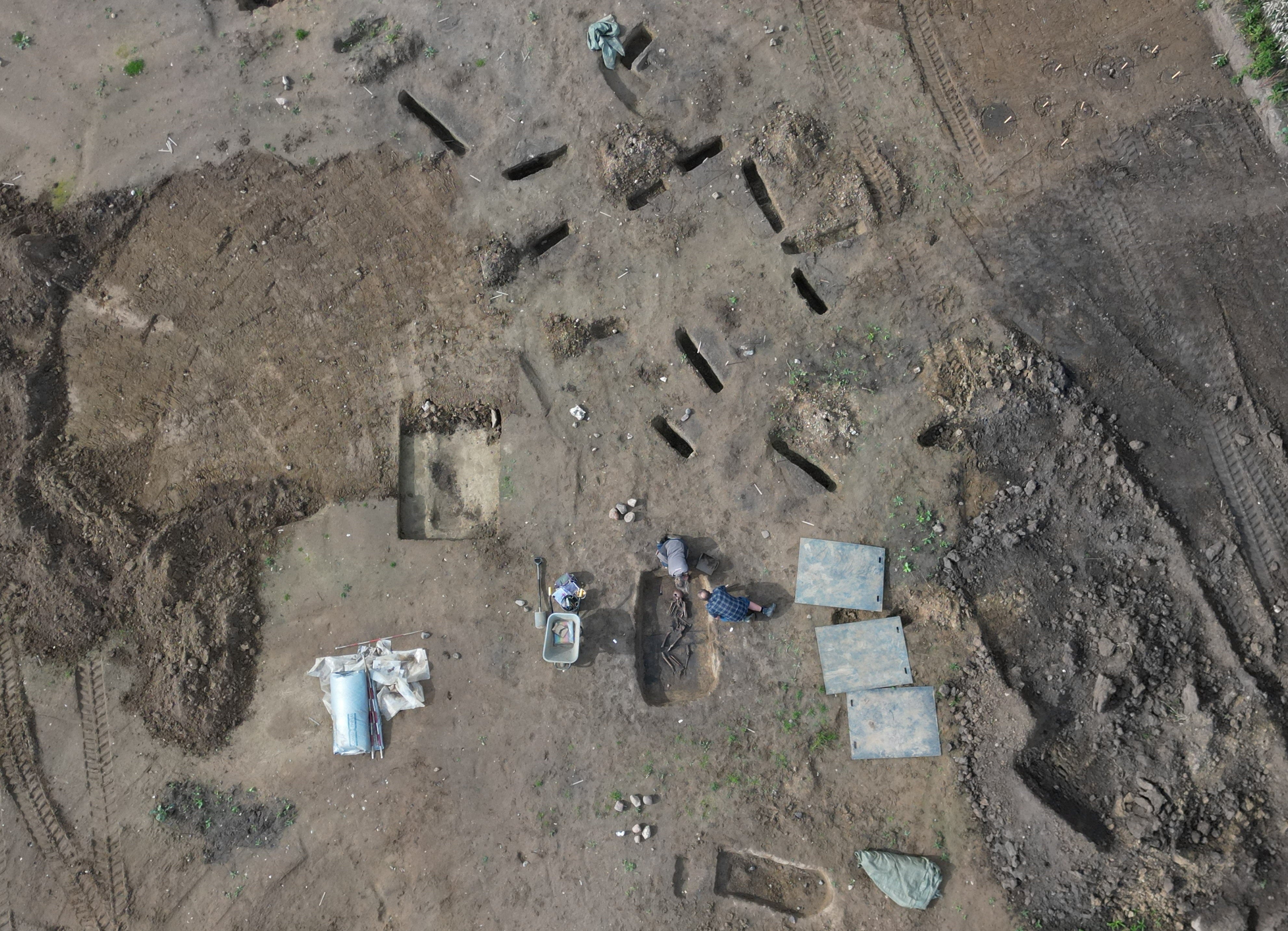 A drone view shows archaeologists working on excavations in the Viking-age burial site found in the village of Aasum, Denmark,