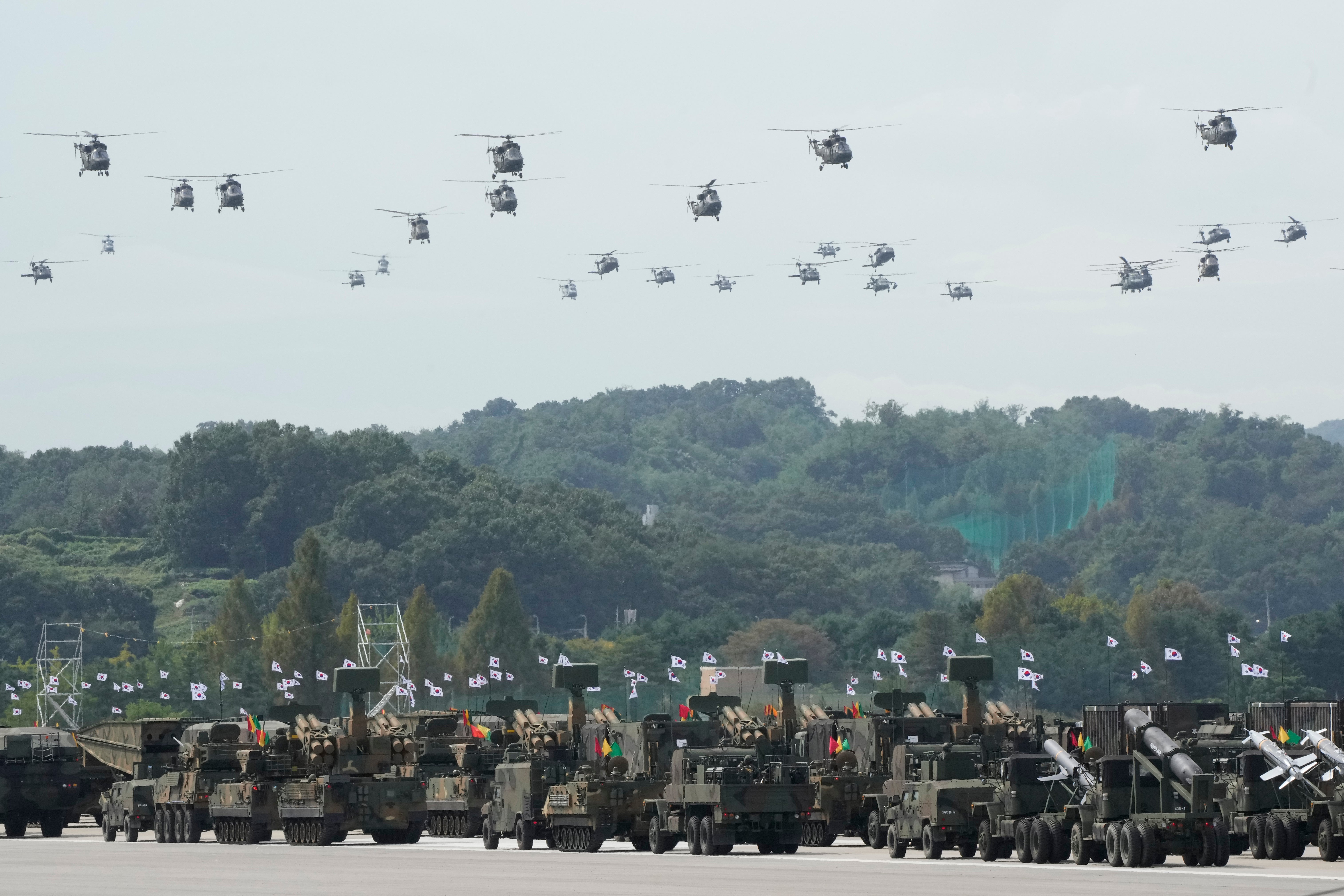 South Korean military helicopters fly over armored vehicles during the media day for the 76th anniversary of Armed Forces