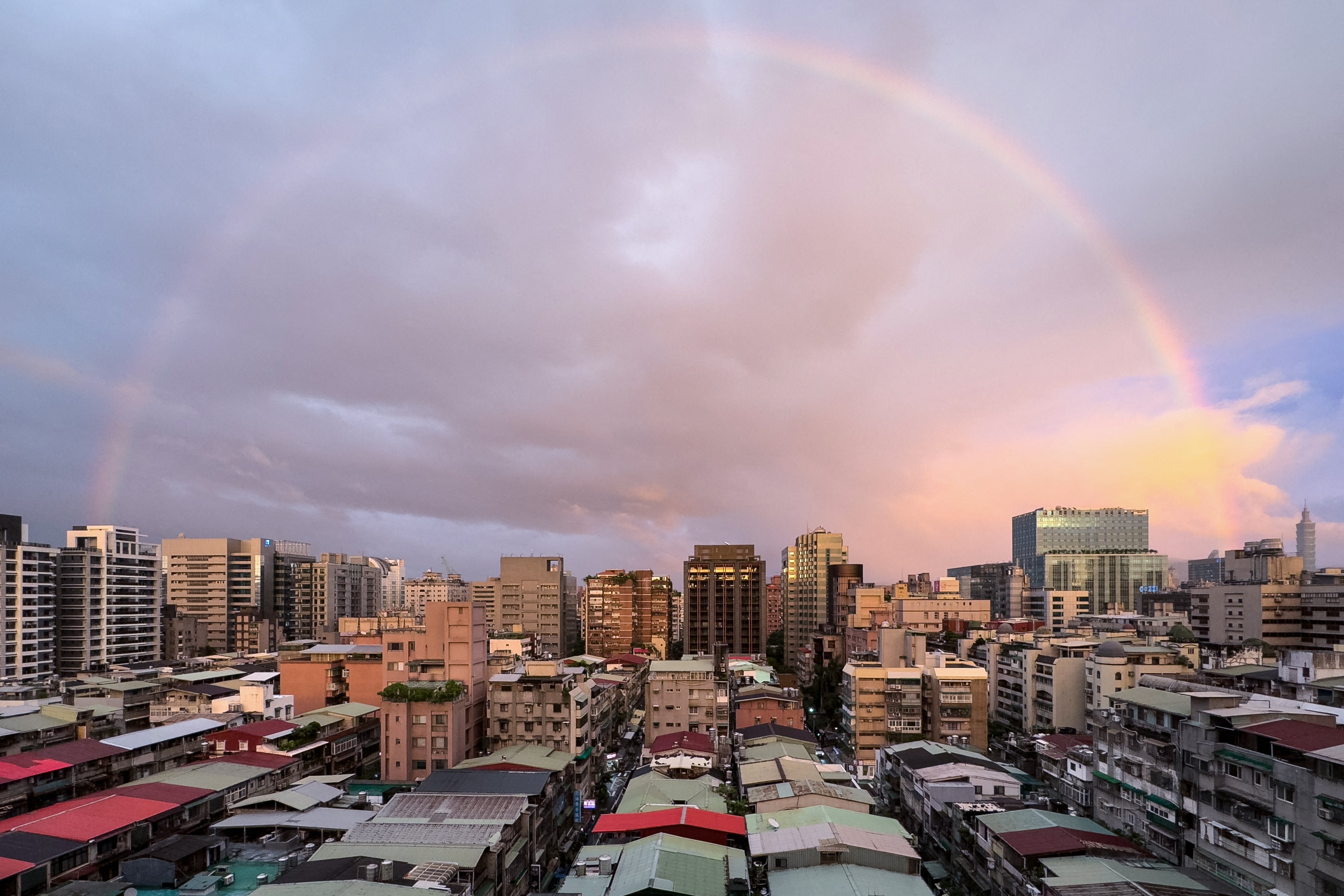 A rainbow is seen over the city of Taipei during sunset