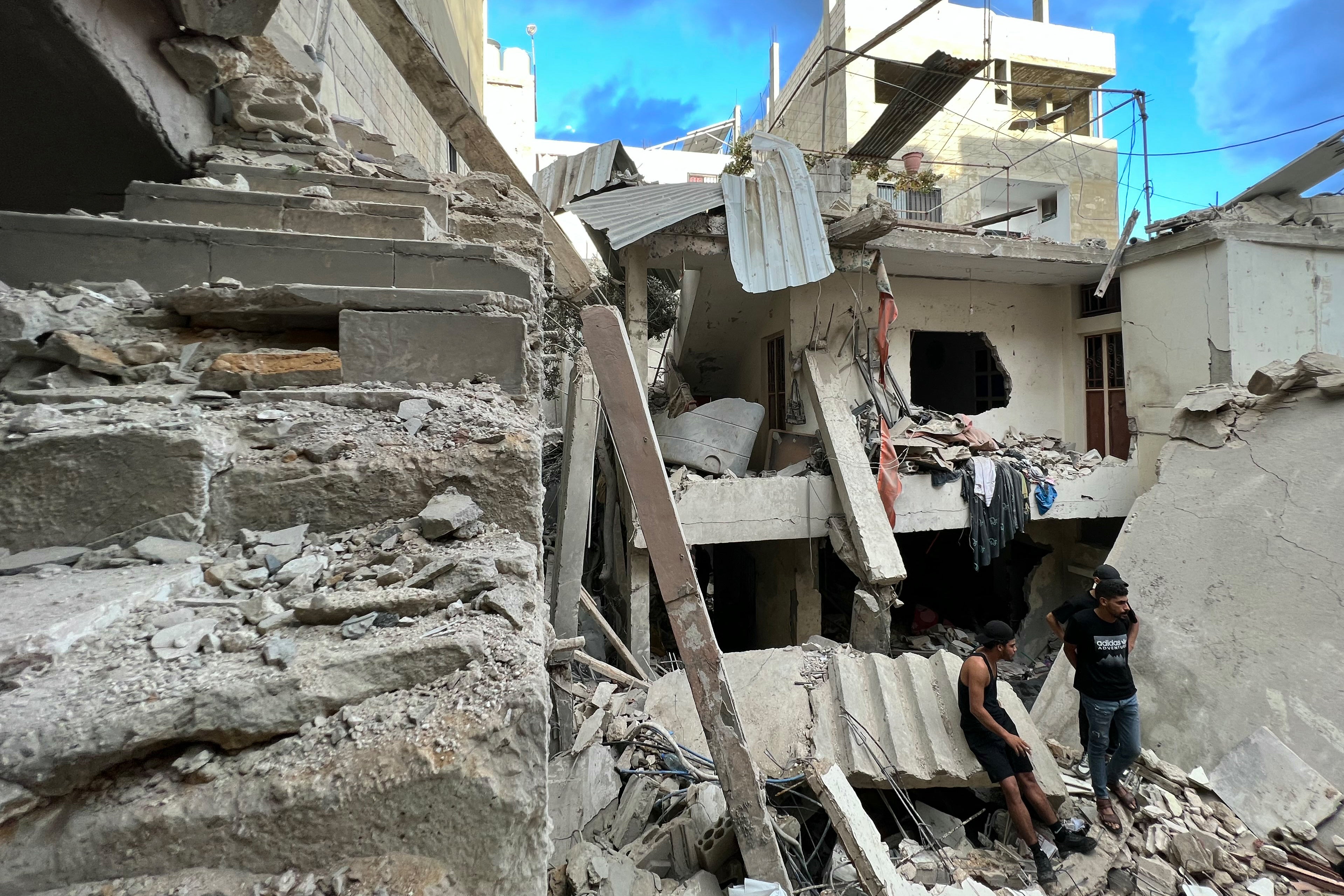 Residents inspect the damage following an overnight Israeli airstrike on the Ain al-Helweh camp for Palestinian refugees on the outskirts of the southern port city of Sidon, Lebanon