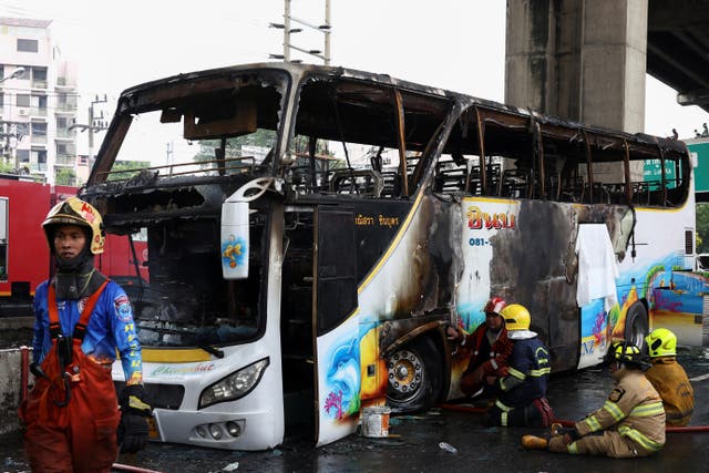 <p>Firefighters work to extinguish a burning bus that was carrying teachers and students from Wat Khao Phraya school</p>