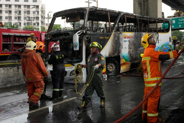 <p>Rescuers work at the site of a bus that caught fire, carrying young students with their teachers, in suburban Bangkok</p>