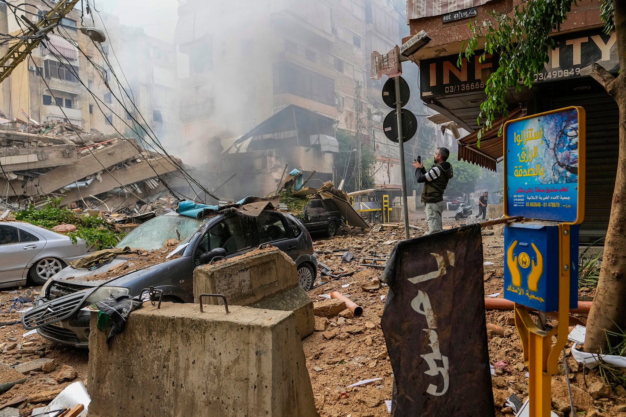 A man documents the damaged buildings at the site of an Israeli airstrike in Beirut’s southern suburb