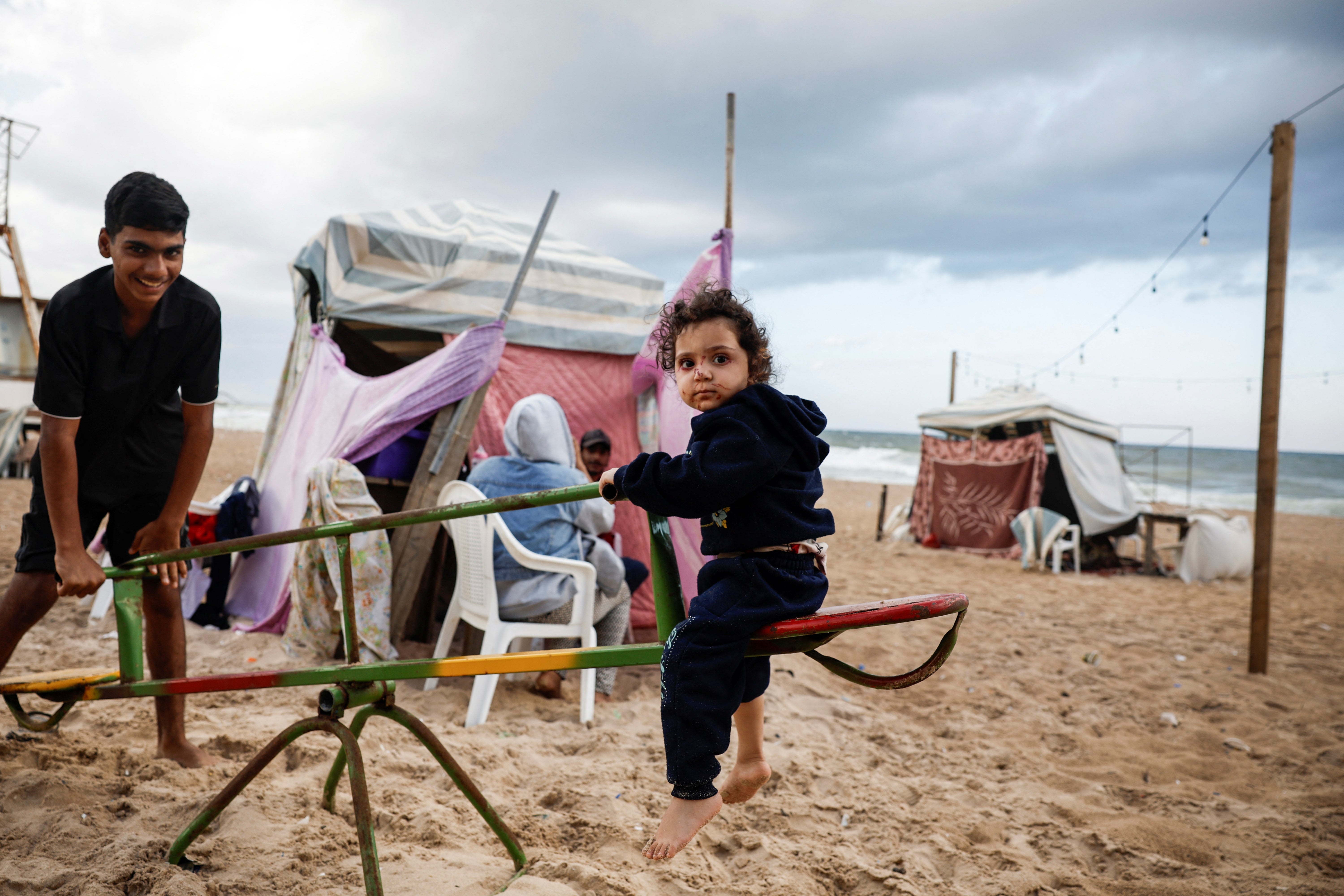 Displaced children from Syria play at a makeshift encampment where scores of displaced people live, amid hostilities between Hezbollah and Israeli forces, at a beach in Beirut, Lebanon