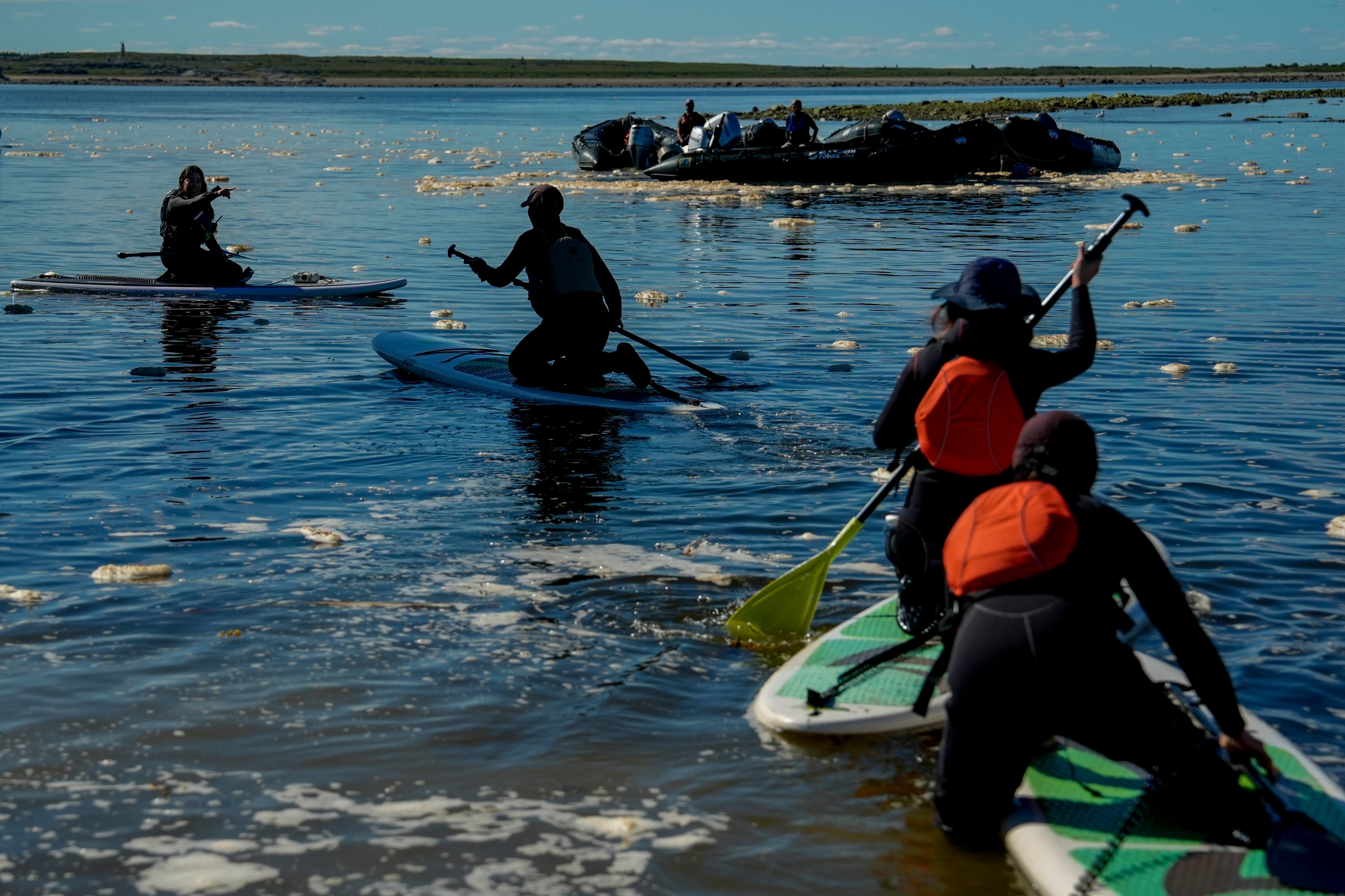 Erin Greene, left, owner of Sup North, directs a person while leading a paddleboarding tour