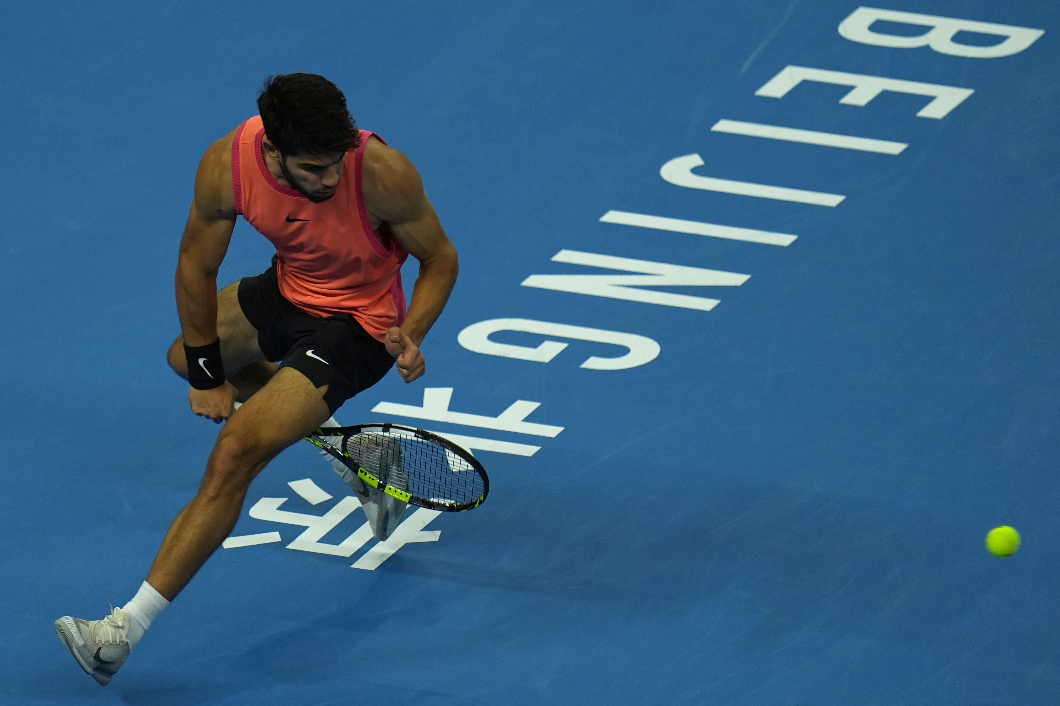 Carlos Alcaraz plays a shot between his legs (Ng Han Guan/AP)