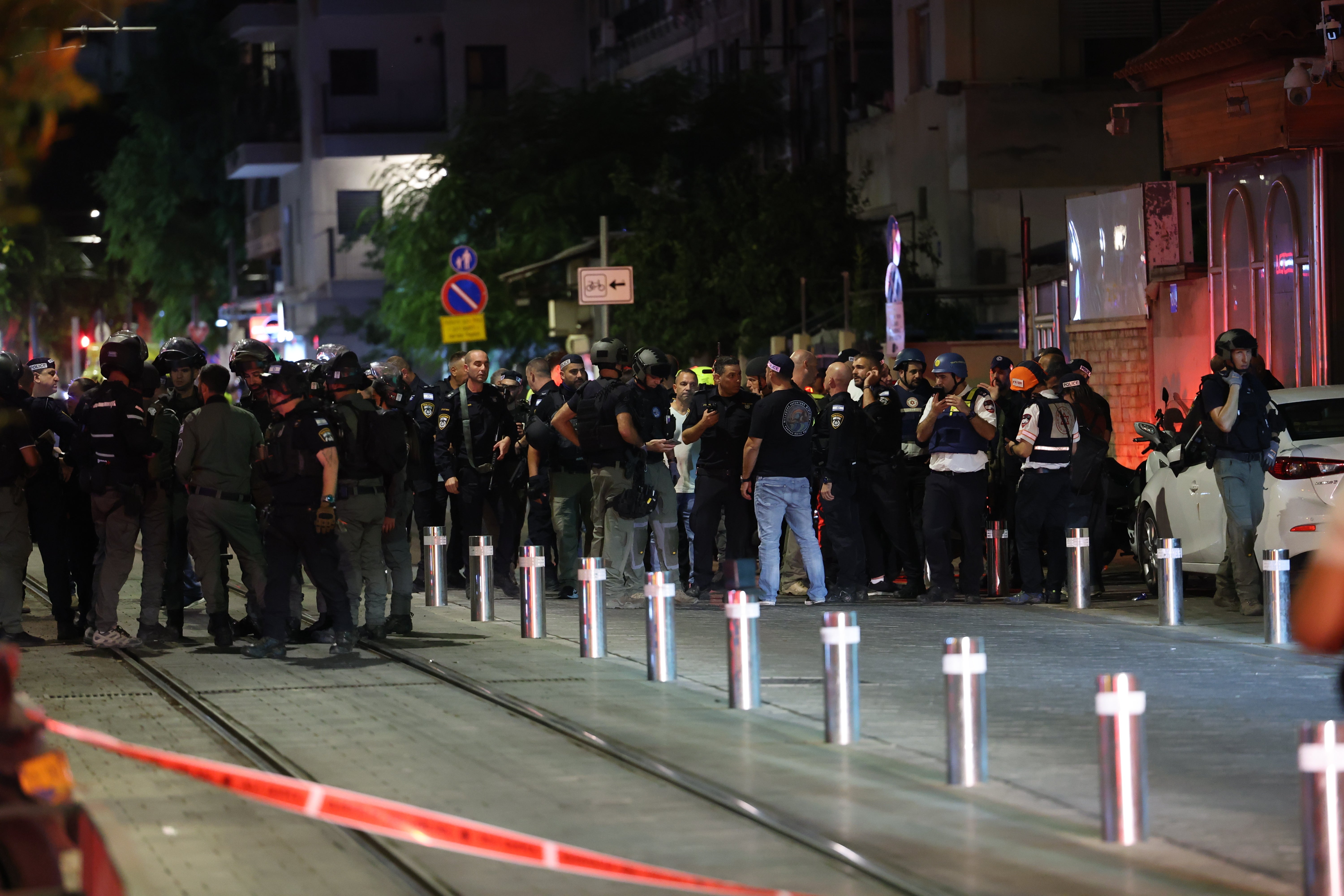 Israeli security and police officers inspect the site of the shooting attack