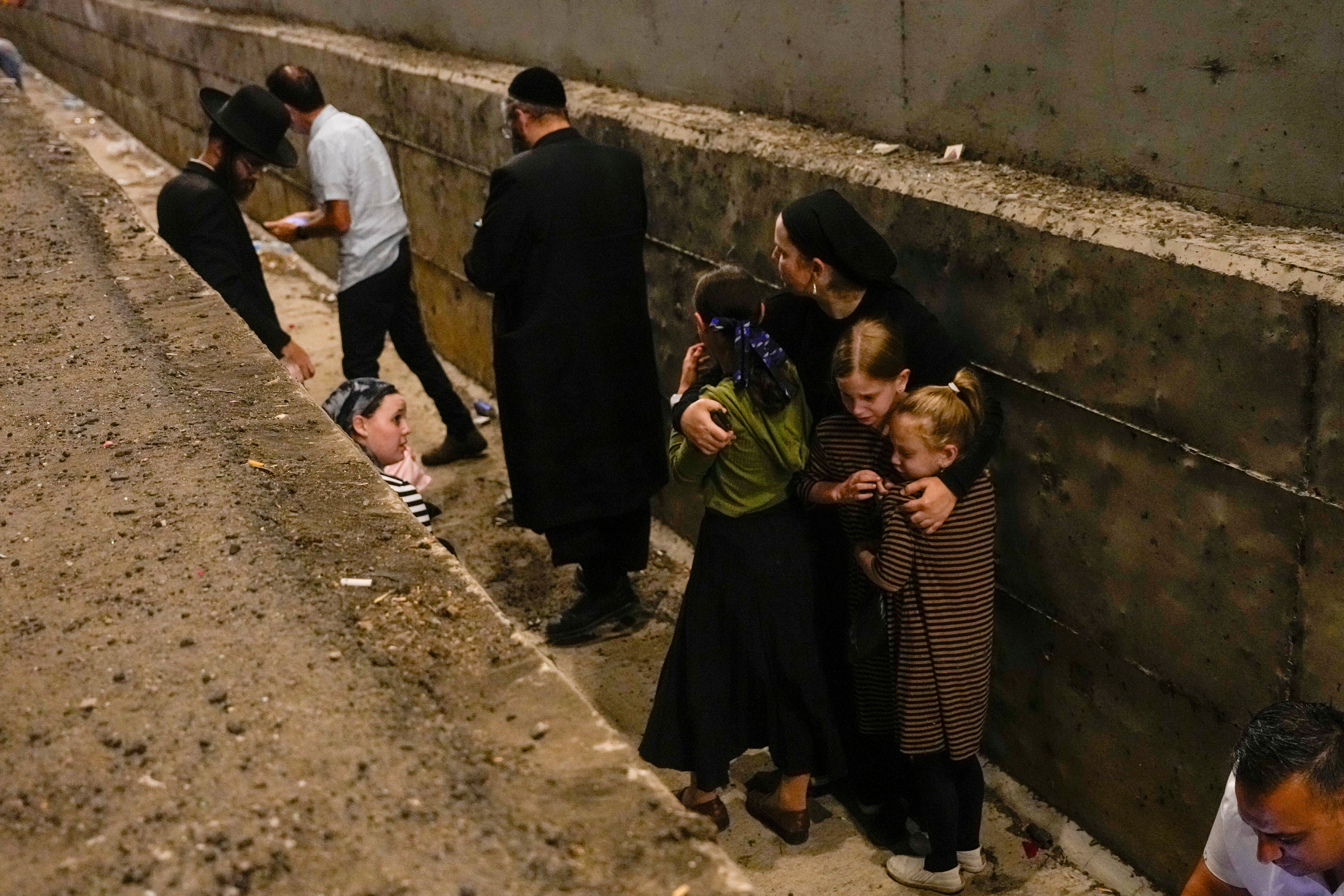 People take cover on the side of the road as a siren sounds a warning of incoming missiles fired from Iran on a freeway in Shoresh between Jerusalem and Tel Aviv in Israel on Tuesday