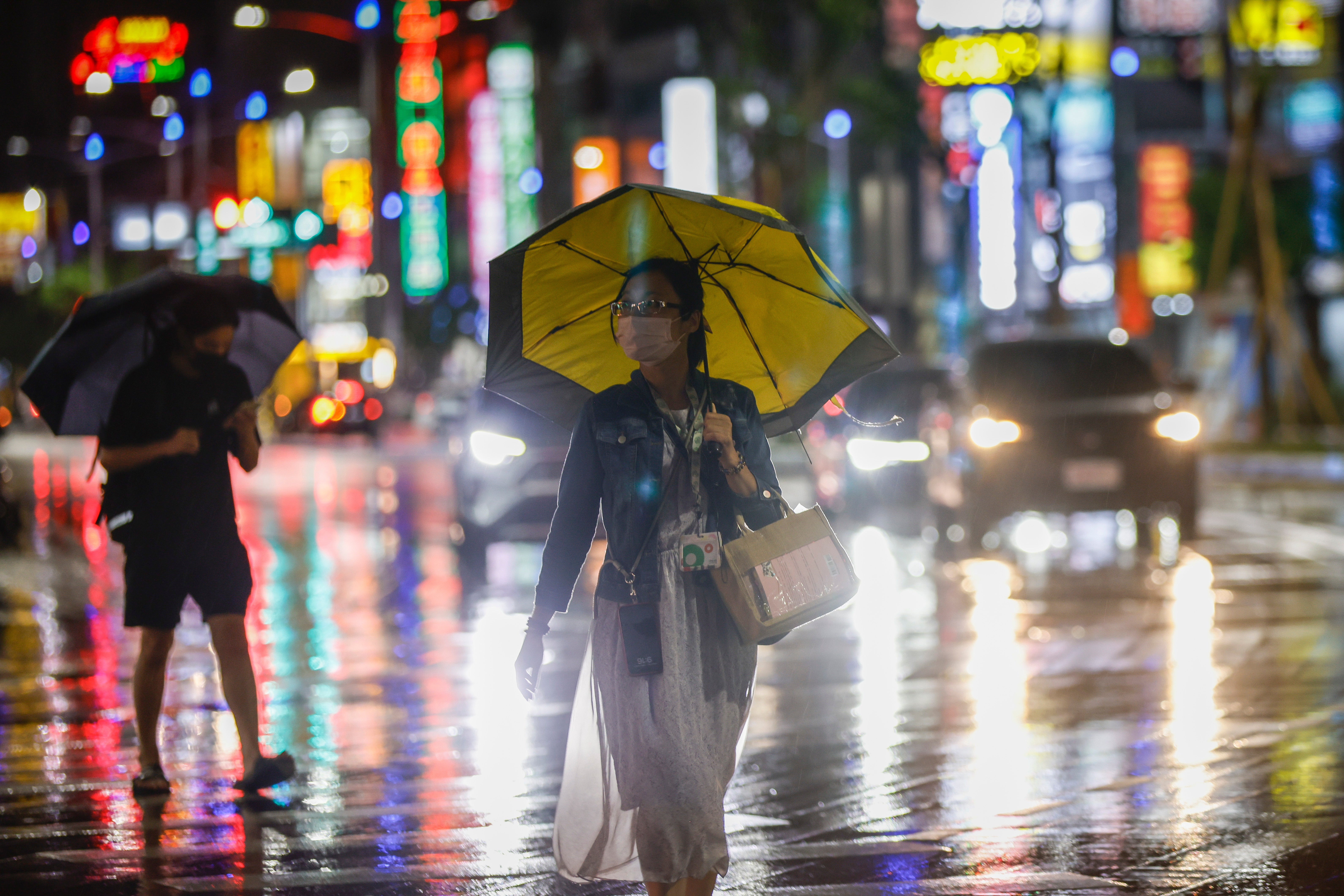 Residents walk through the rain brought by Typhoon Krathon in Kaohsiung city, Taiwan