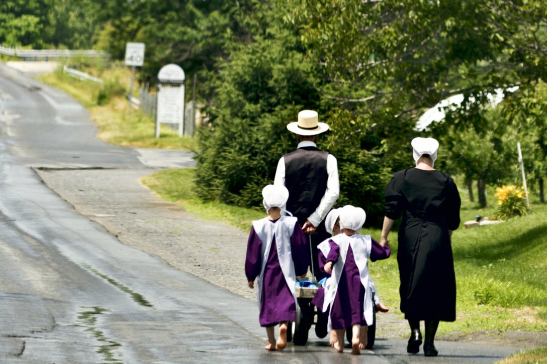 After returning from Sunday church an Amish family walks bare feet over a country road in the heart of rural Lancaster County, Pennsylvania, on June 24, 2018.