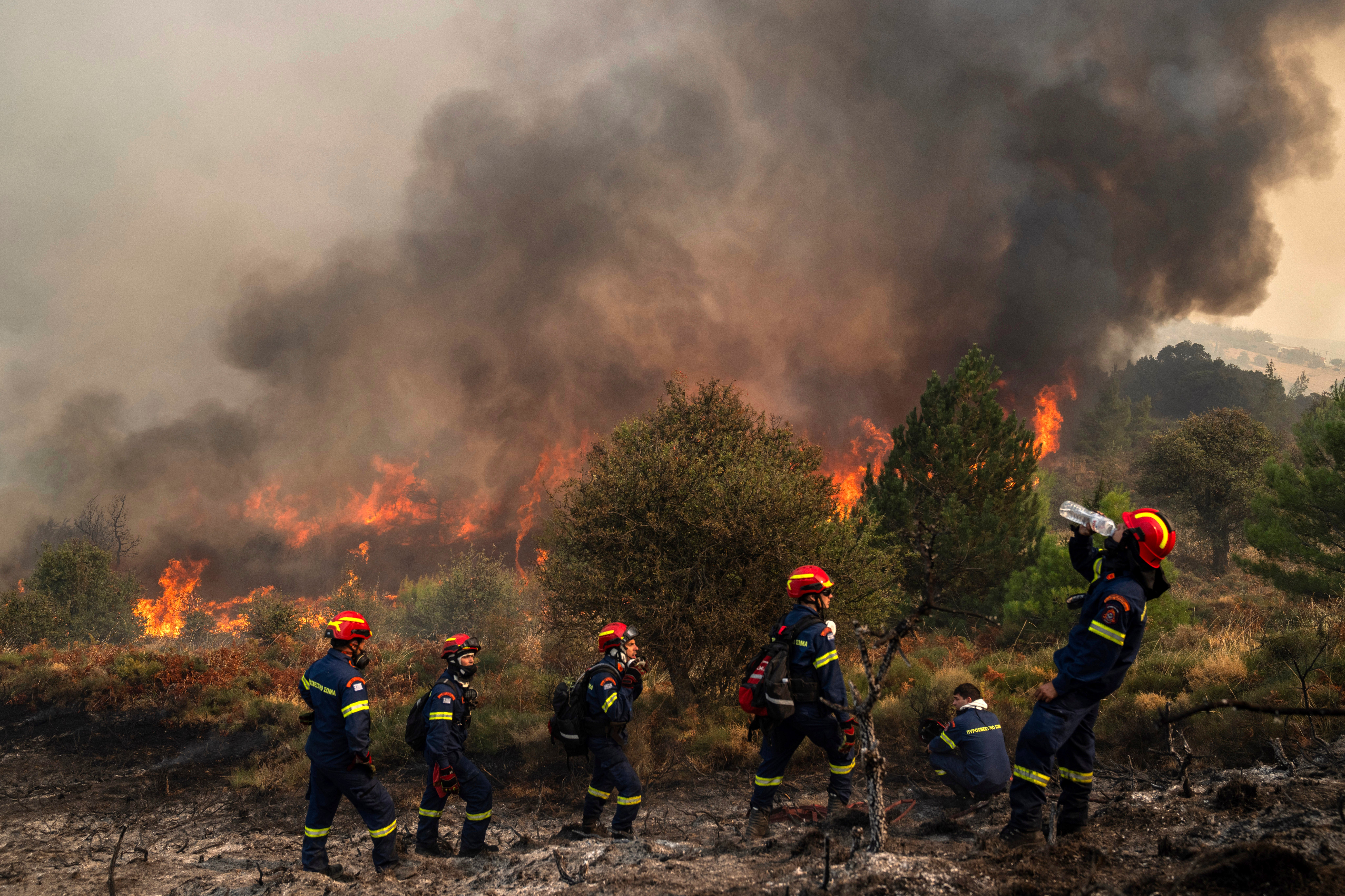 A firefighter drinks water during a third day of a wildfire in Sofiana village, about 142 kilometers (88 miles) west of Athens, Greece, on Tuesday, October 1