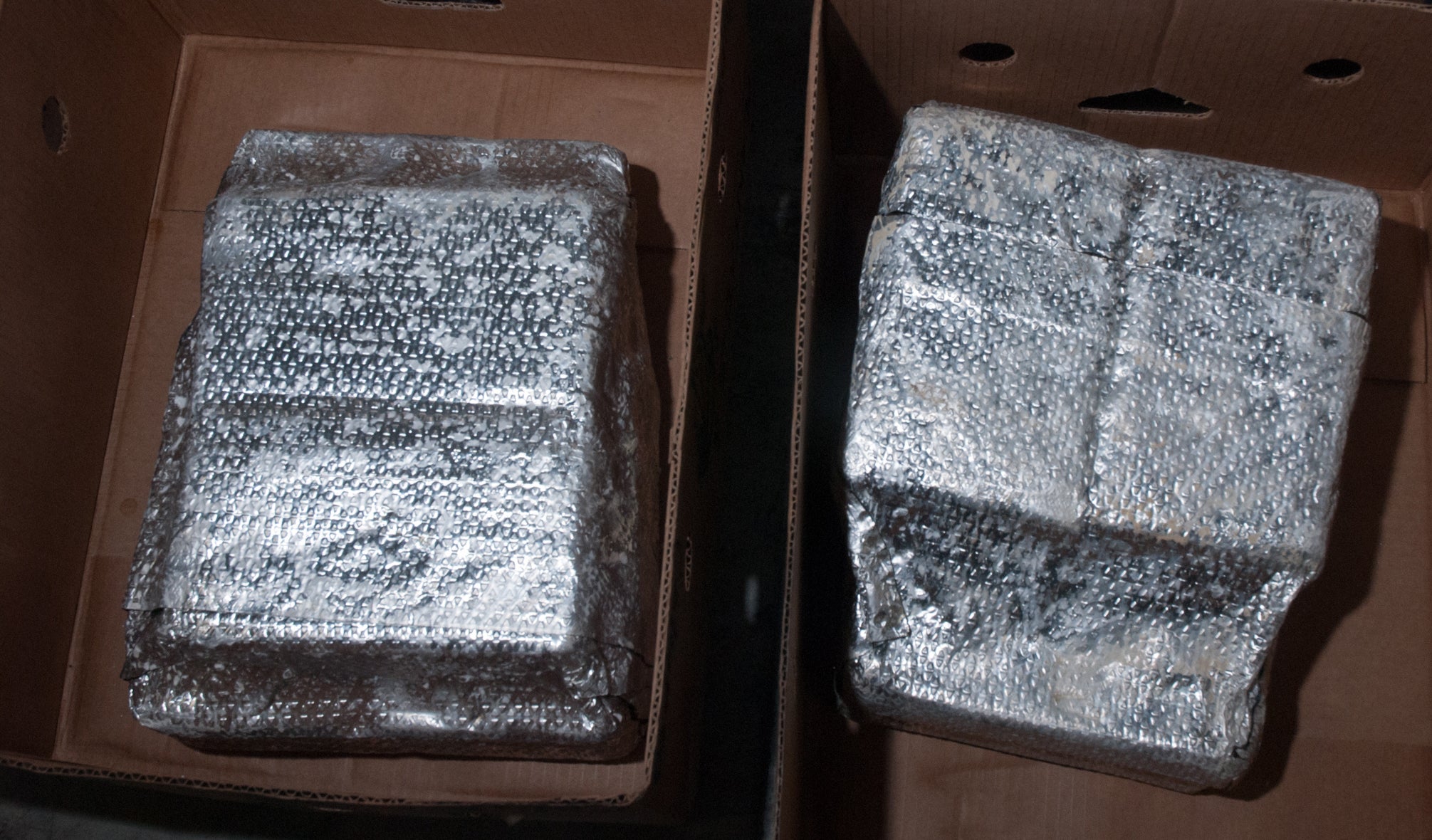 Banana crates lined up, with the foil packages that were found inside them