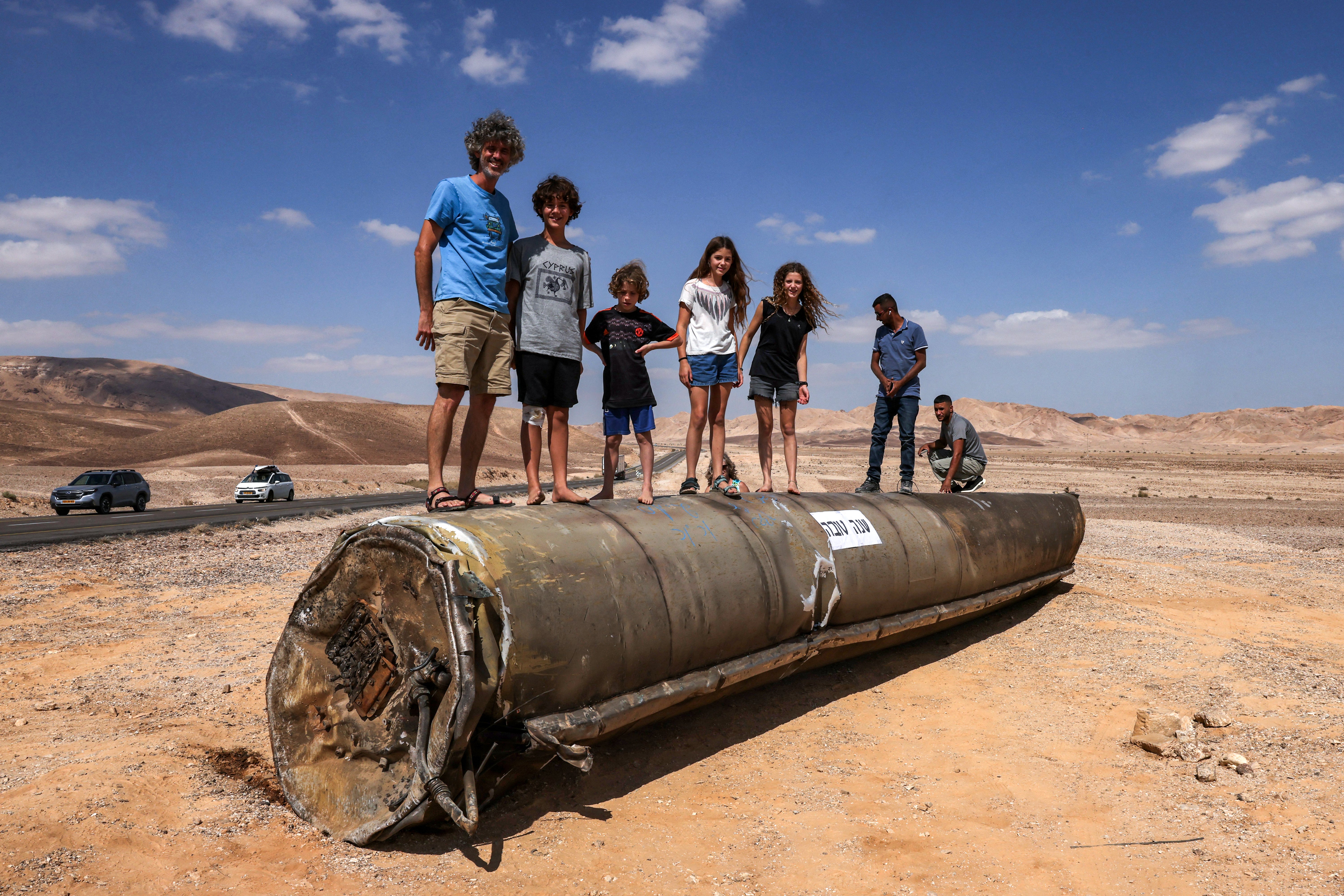 Israelis stand on top of the remains of an Iranian missile in the Negev desert near Arad, on the border with Jordan