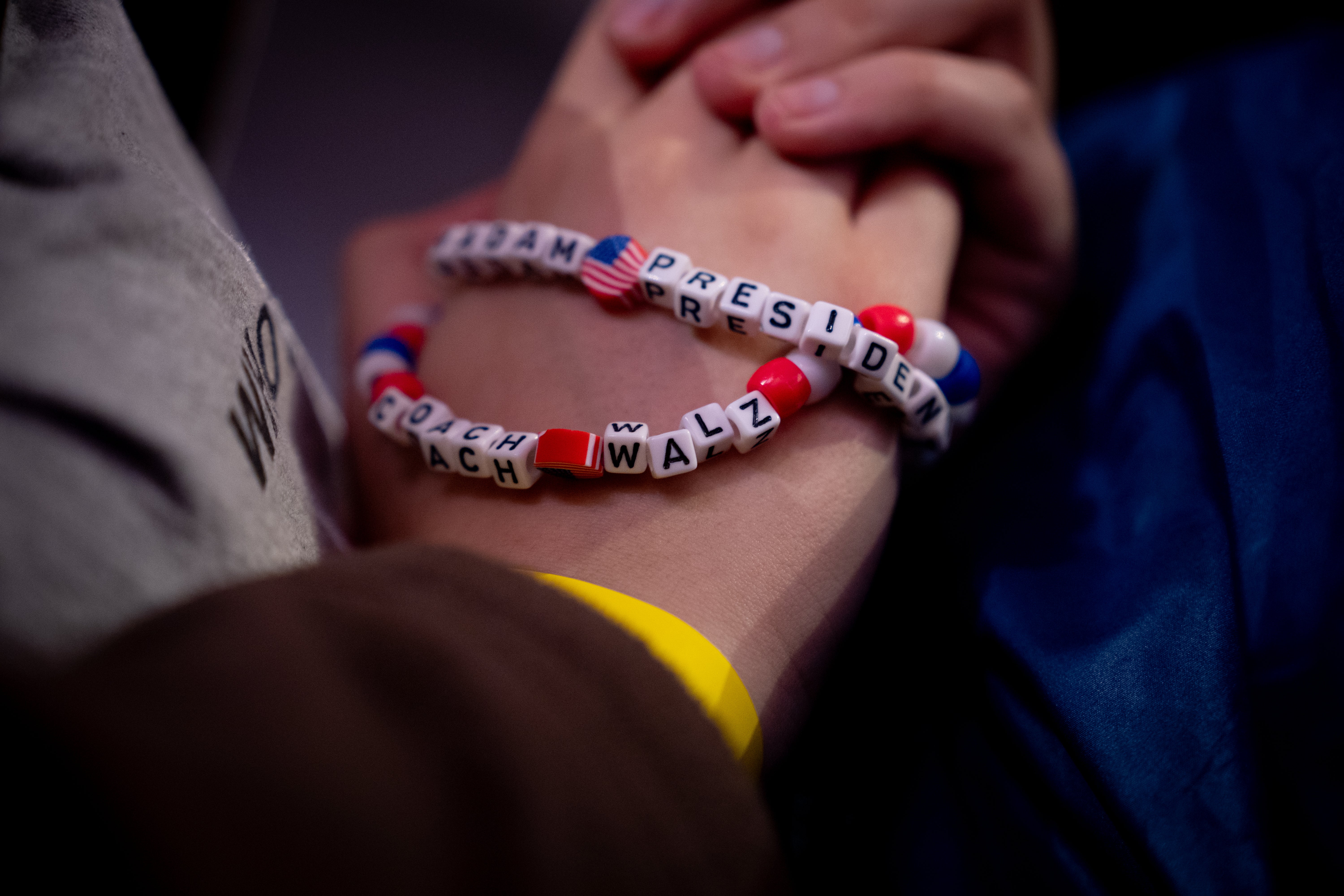 A woman in the audience wears bracelets that read “Madame President” and “Coach Walz” as Democratic vice presidential candidate Minnesota Gov. Tim Walz speaks at a rally in Pennsylvania