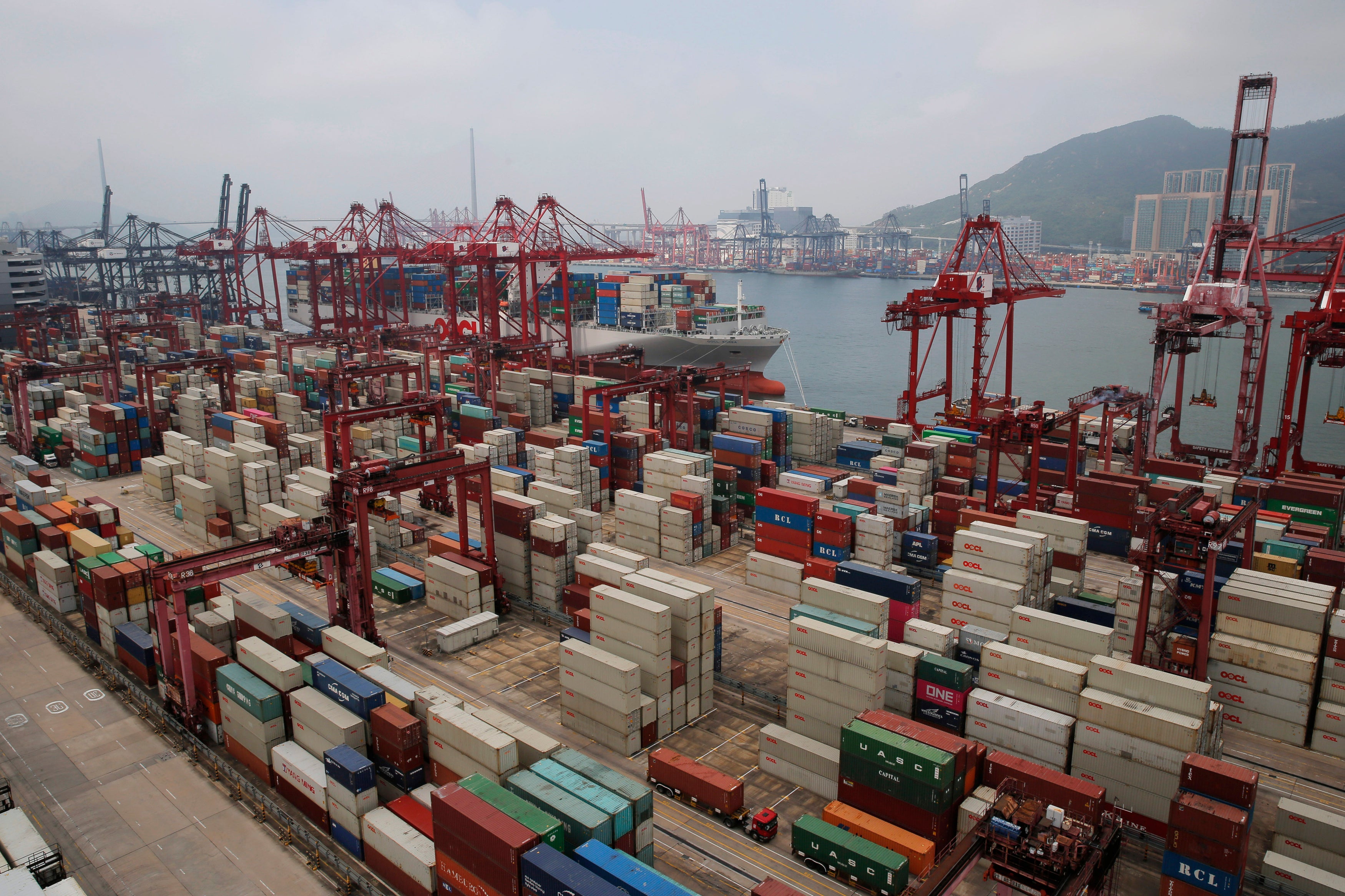 Gantry cranes load cargo onto container ships at a port of Kwai Tsing Container Terminals in Hong Kong