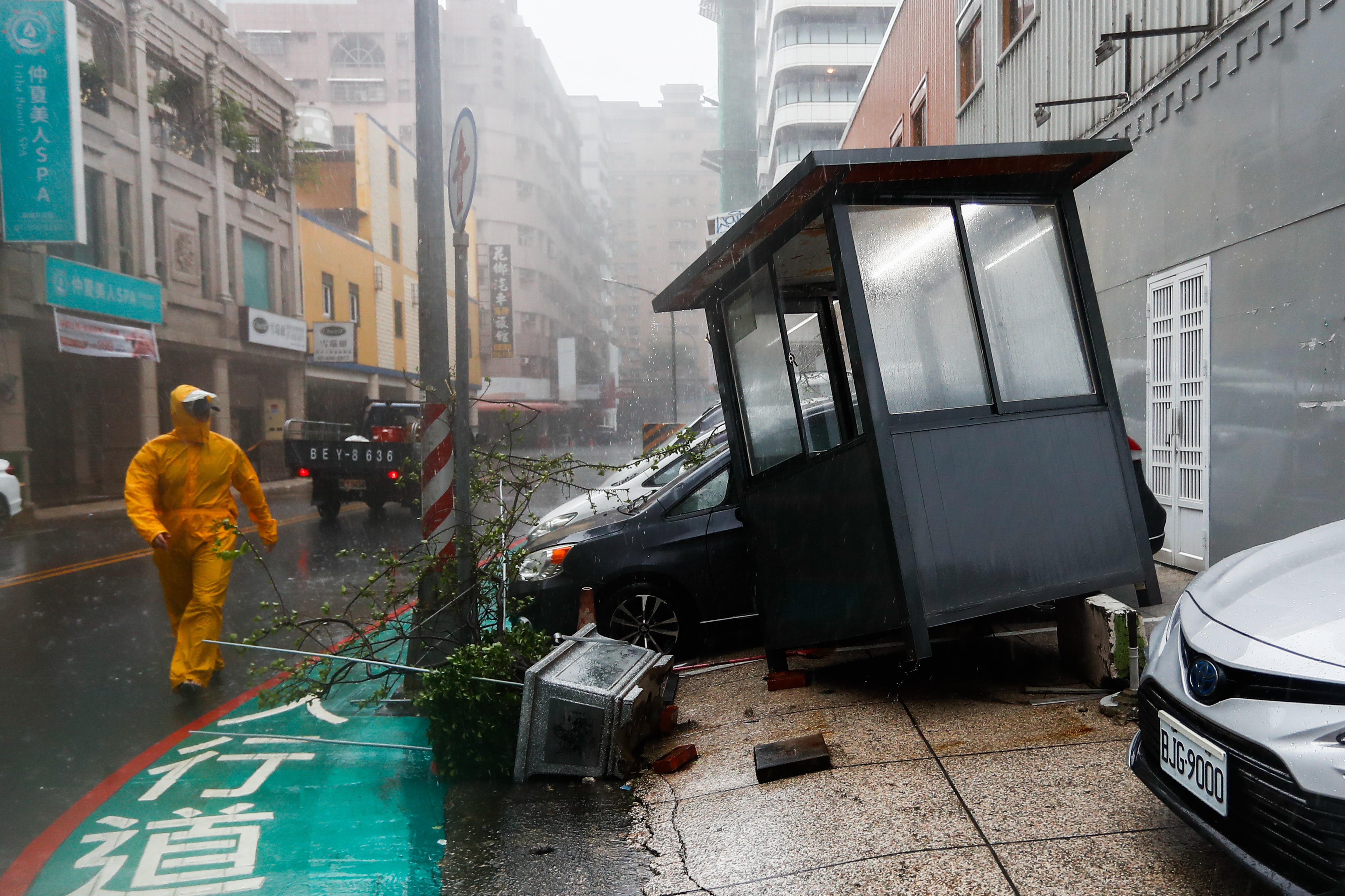 A security guard inspects a guard house after Typhoon Krathon makes landfall