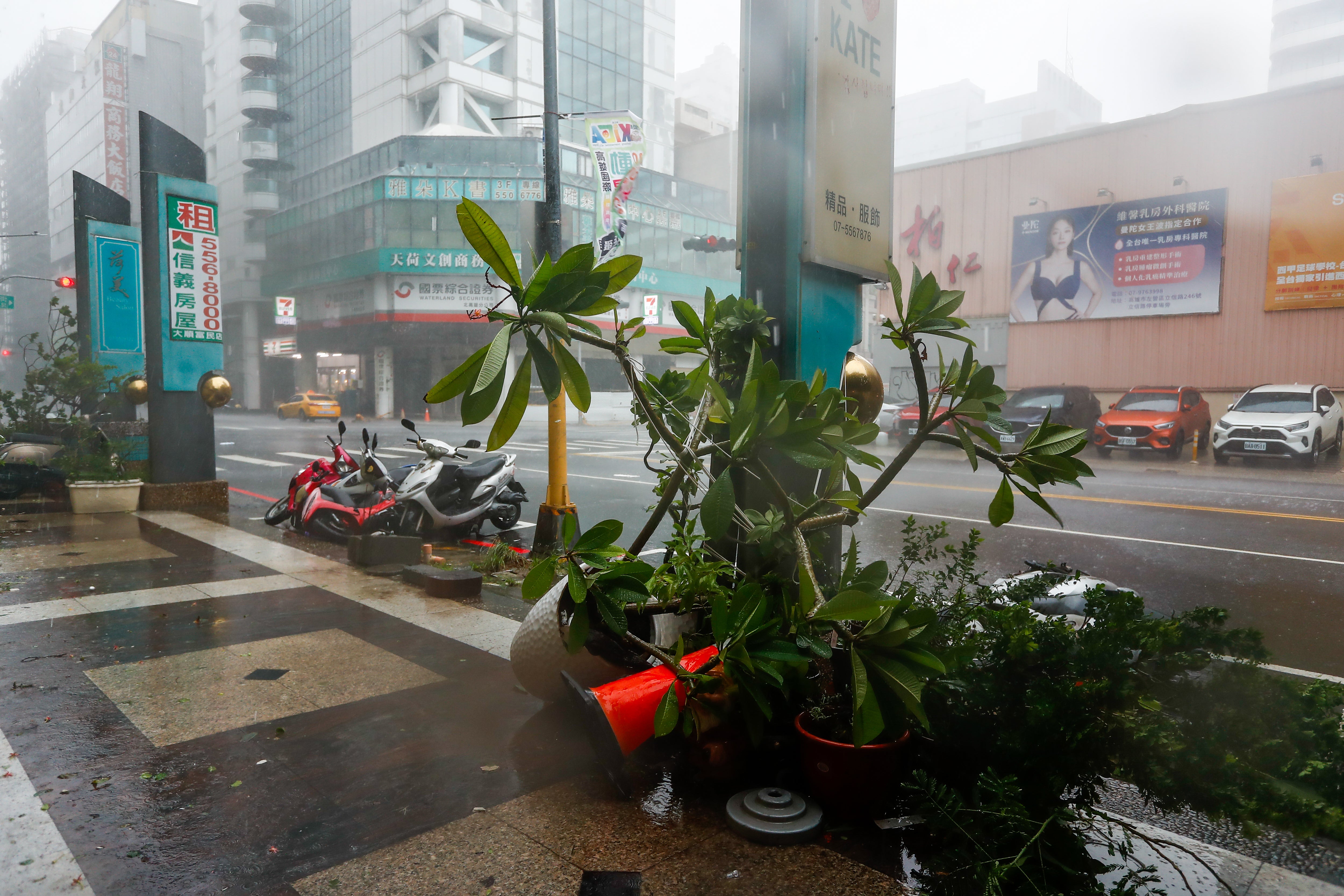 Motorbikes and potted flowers are blown down by powerful winds, as Typhoon Krathon