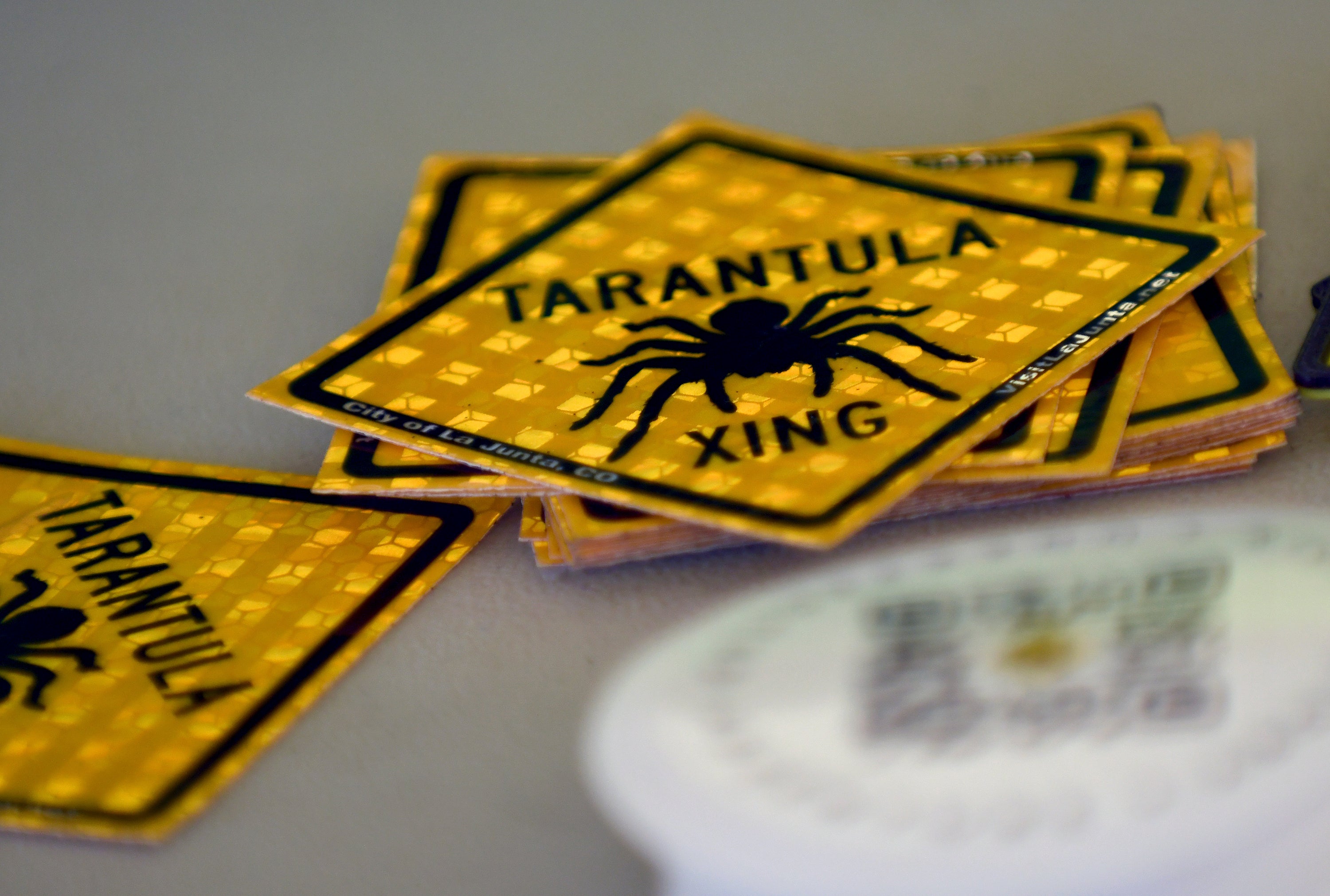 Tarantula crossing stickers are piled on a table at the Tarantula Festival in La Junt