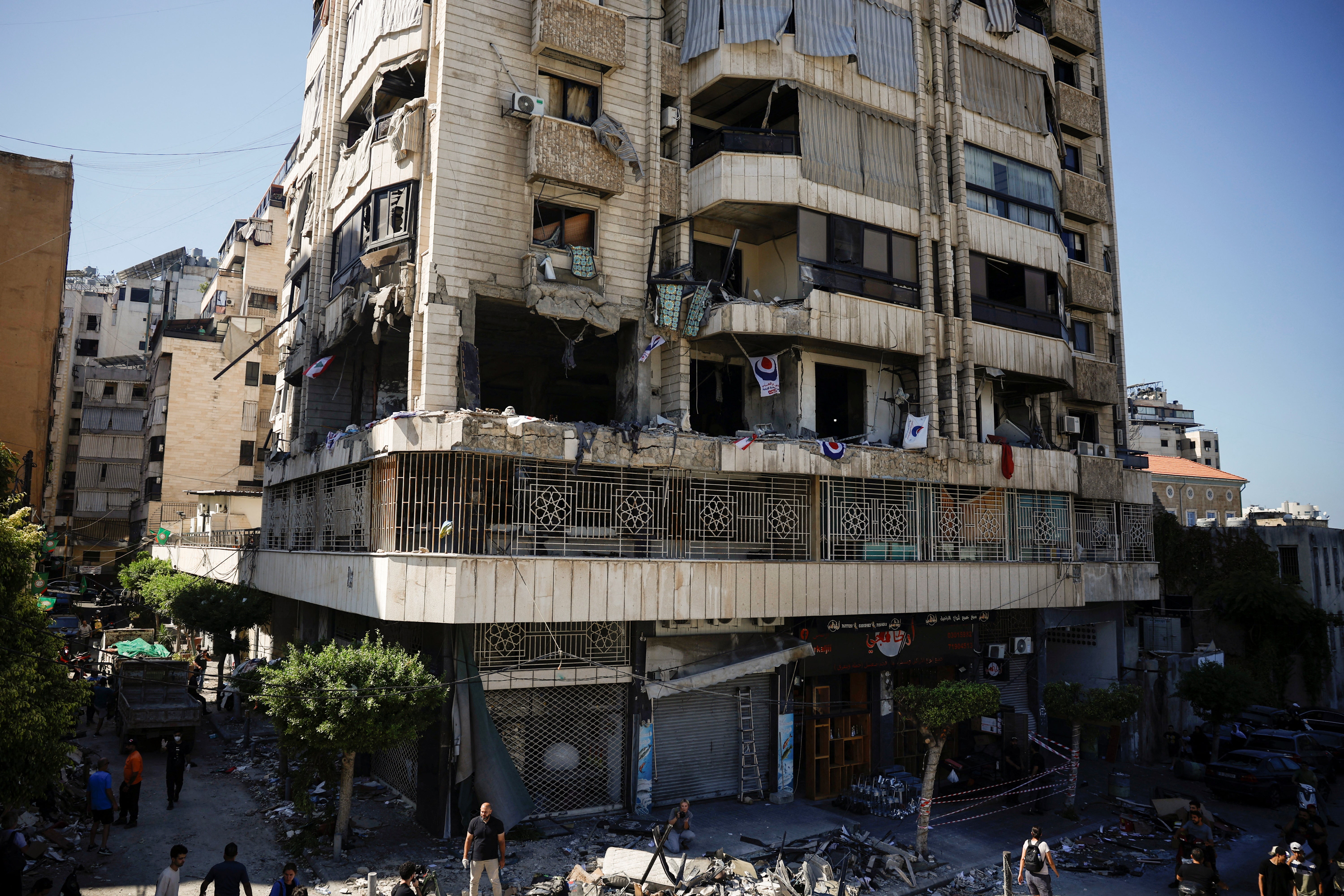 People look at a damaged building at the site of an Israeli strike on central Beirut on Thursday