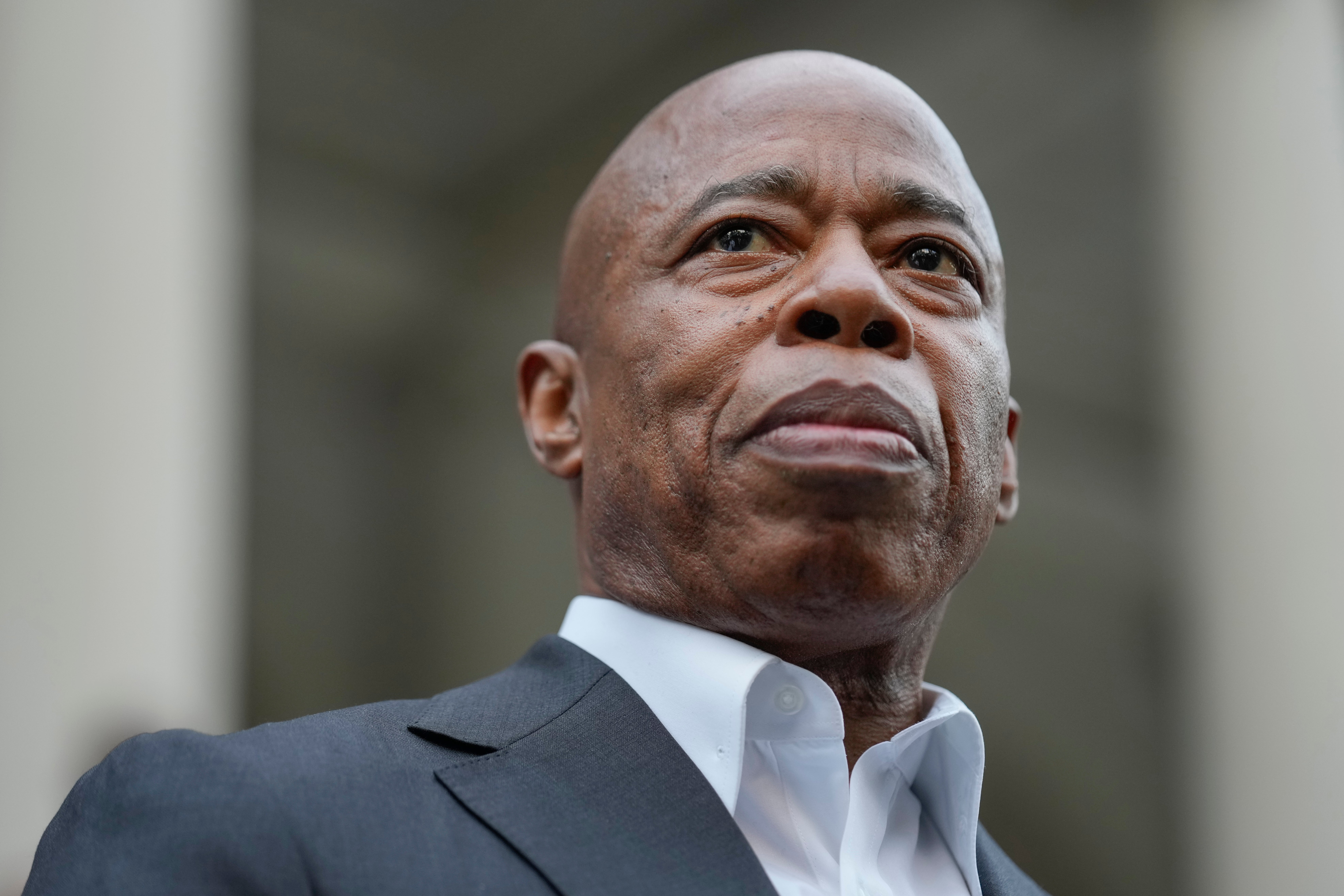 New York City Mayor Eric Adams looks on while surrounded by faith leaders and other supporters during a rally and prayer vigil on the steps of City Hall in New York