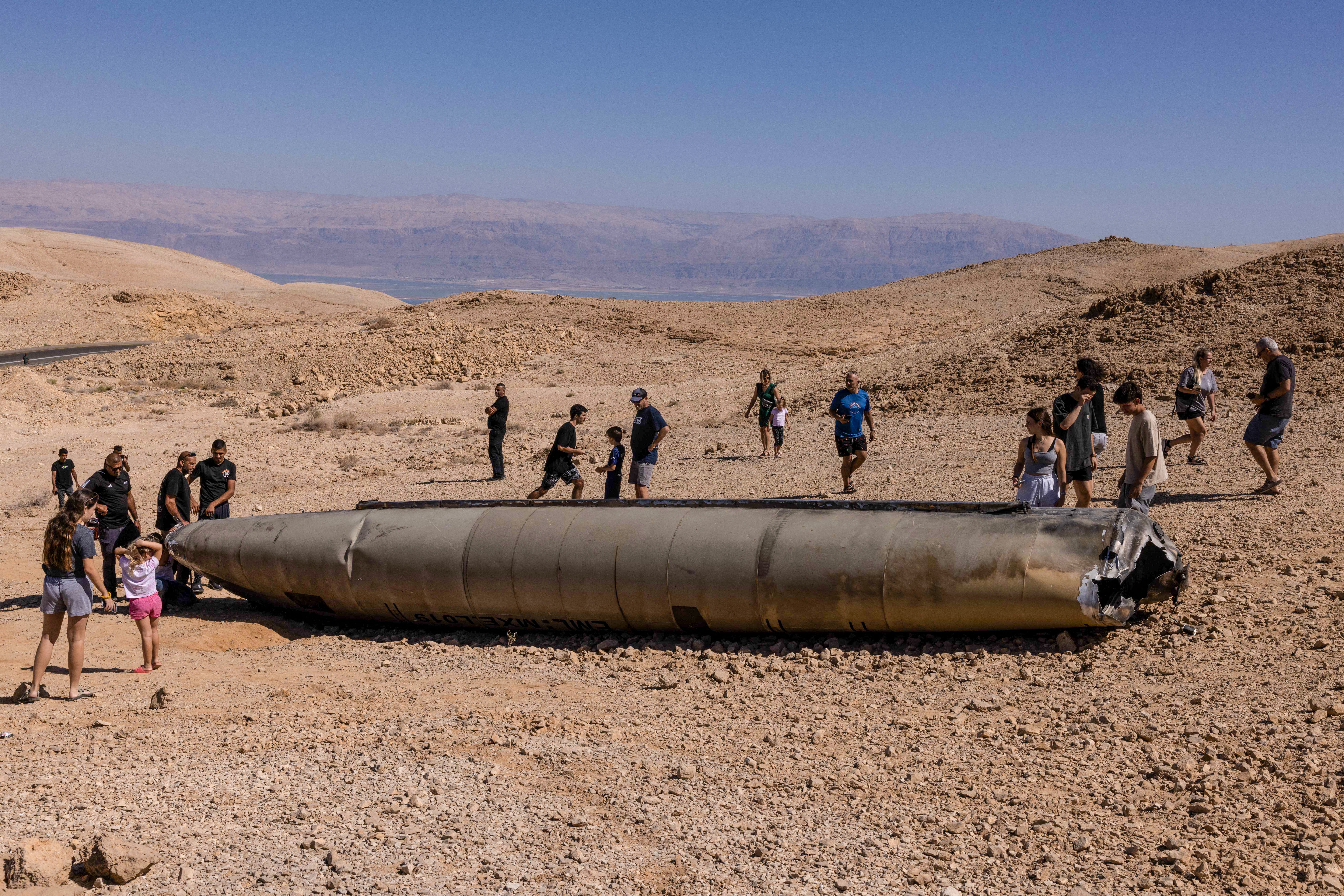 A group gathers around Iranian missile debris in the Negev desert after Tehran launched an attack on Israel earlier this week